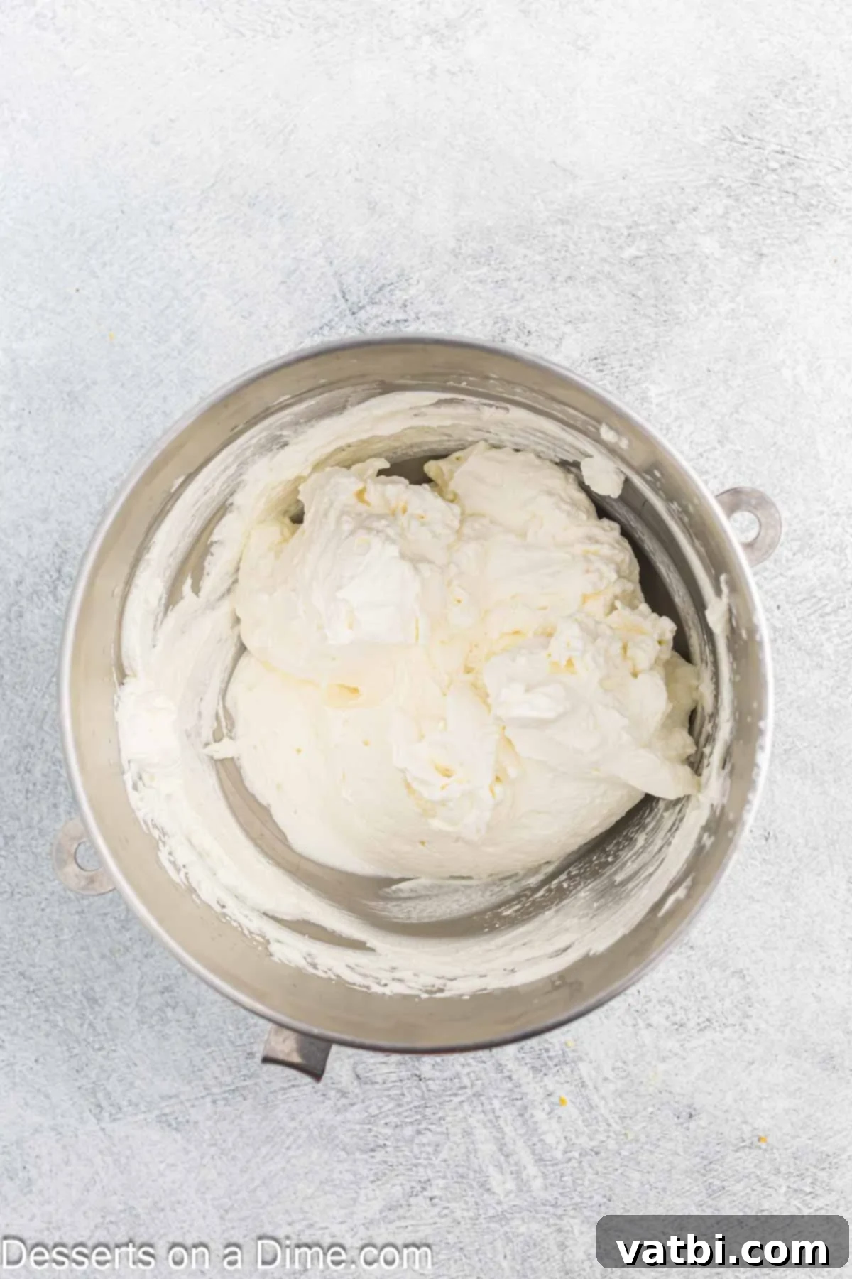 Zesty Lemon Layers 7 Heavy whipping cream being beaten in a bowl, forming soft peaks.