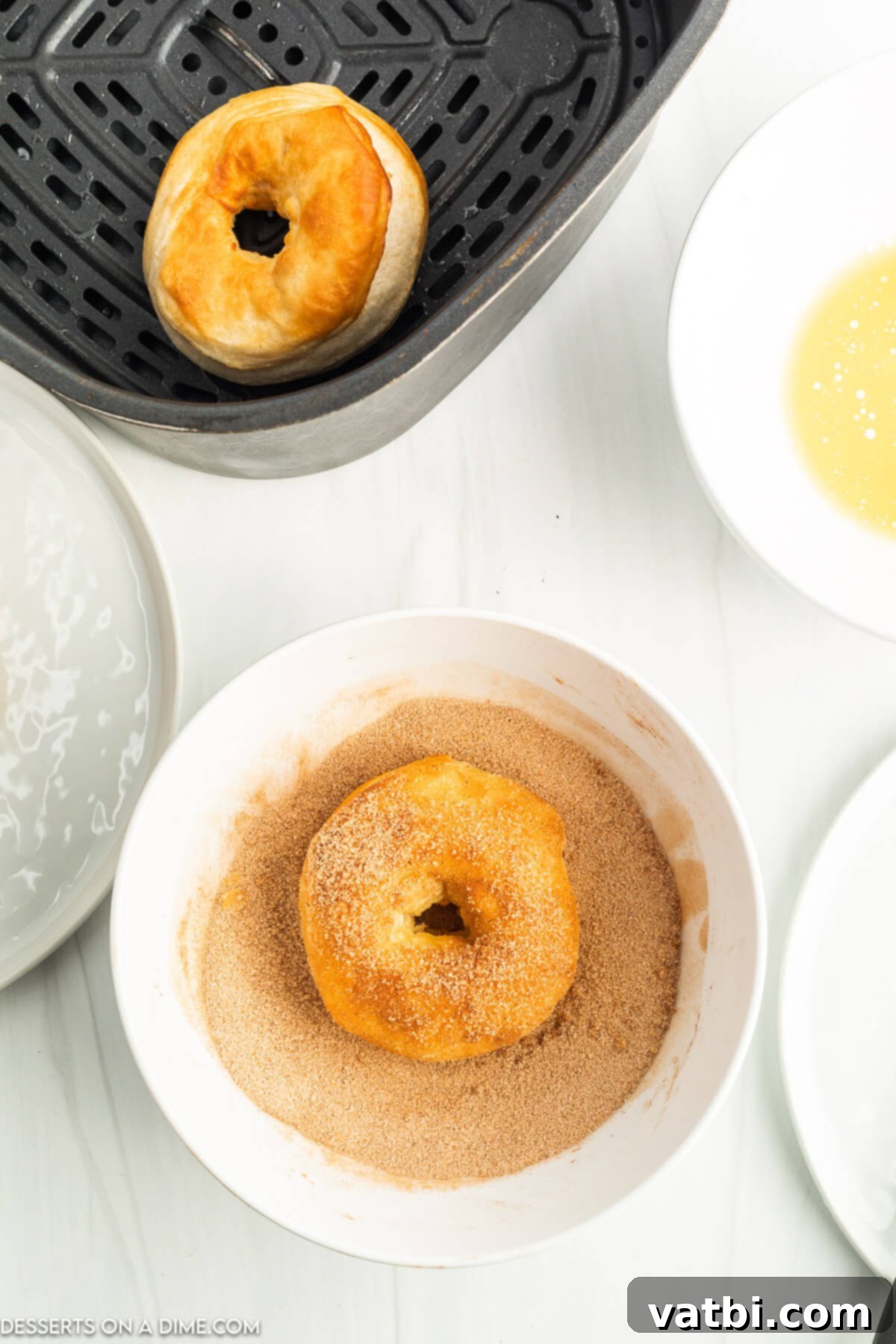 Delicious Air Fryer Donuts Made Easy 8 Cinnamon sugar mixture in bowl with donut.