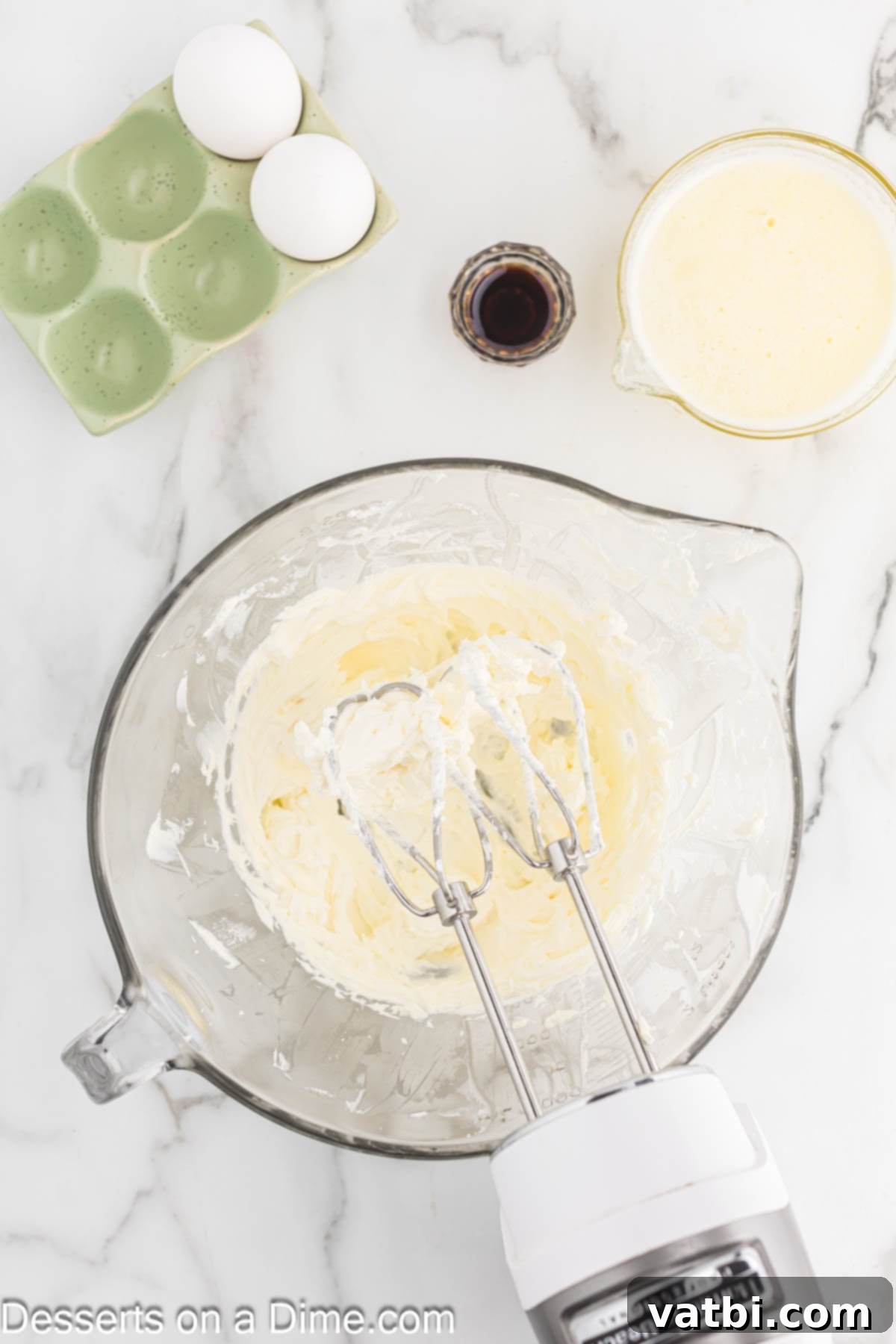 Paula Deen's Signature Ooey Gooey Butter Cake 6 Cream cheese being beaten until smooth and creamy in a mixing bowl.