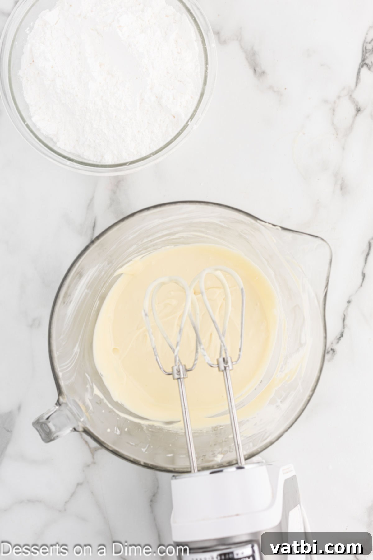 Paula Deen's Signature Ooey Gooey Butter Cake 7 Eggs, melted butter, and vanilla extract added to the cream cheese mixture in a bowl.
