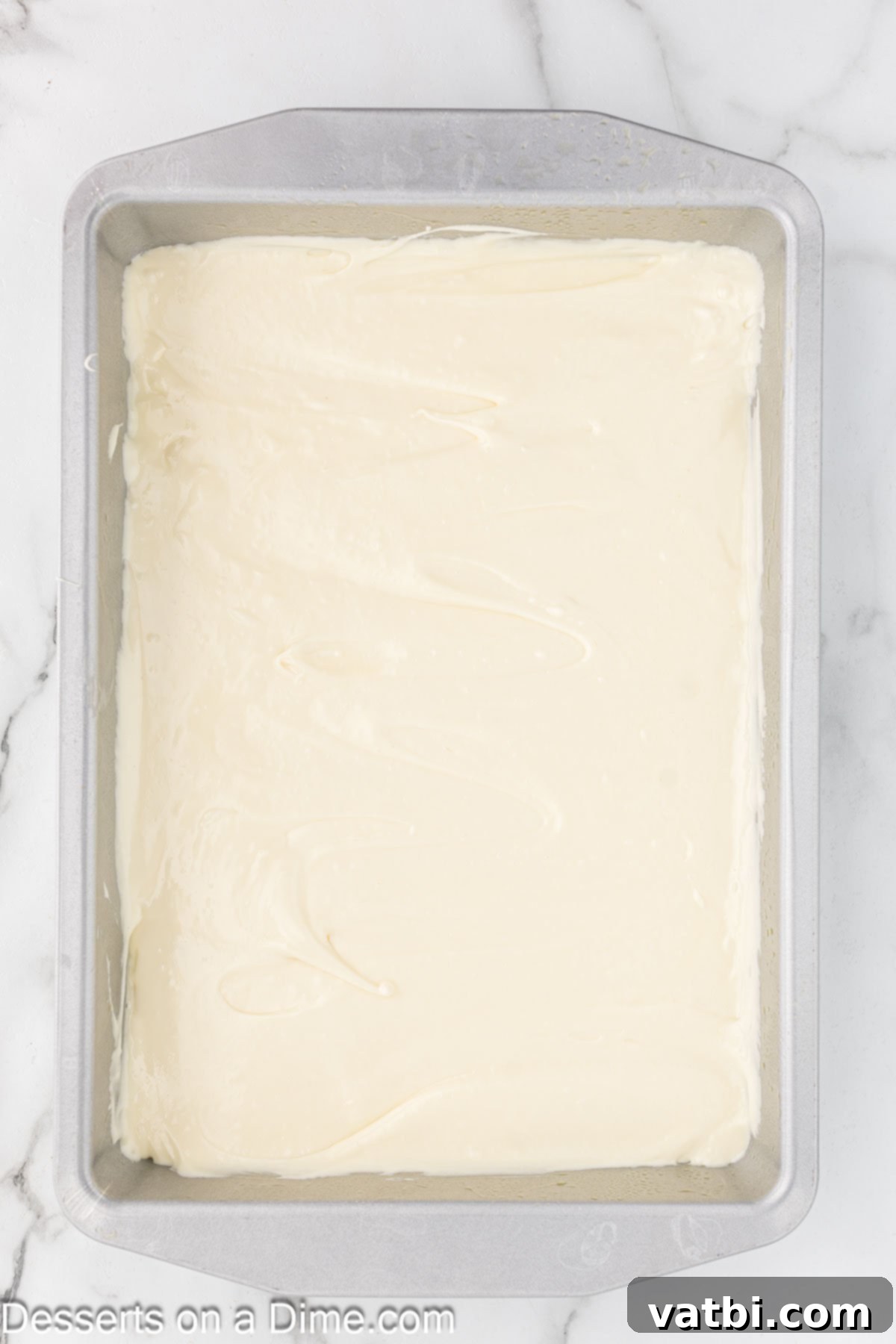 Paula Deen's Signature Ooey Gooey Butter Cake 8 Creamy filling spread evenly over the cake crust in a baking dish, ready for the oven.