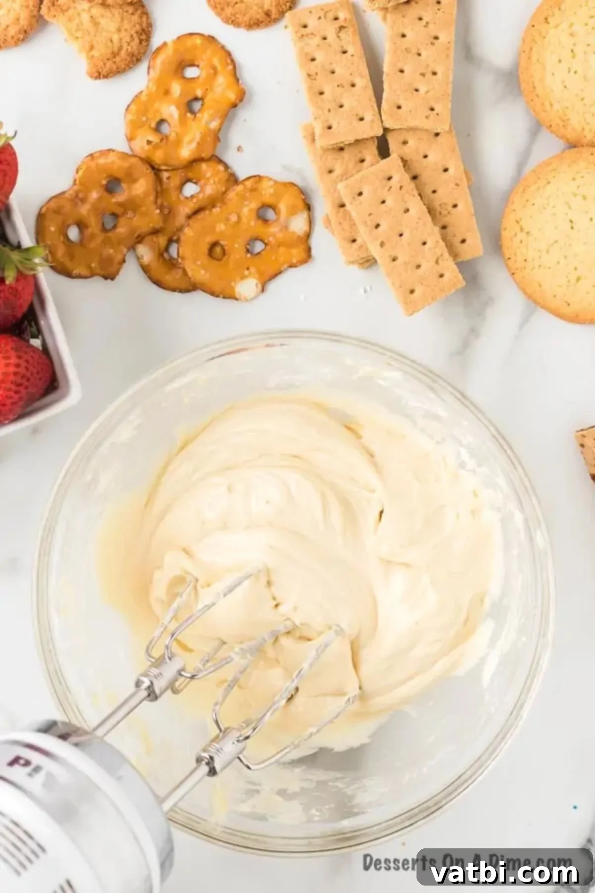 All ingredients for the cheesecake dip are fully combined in a mixing bowl, showing a smooth and uniform consistency.