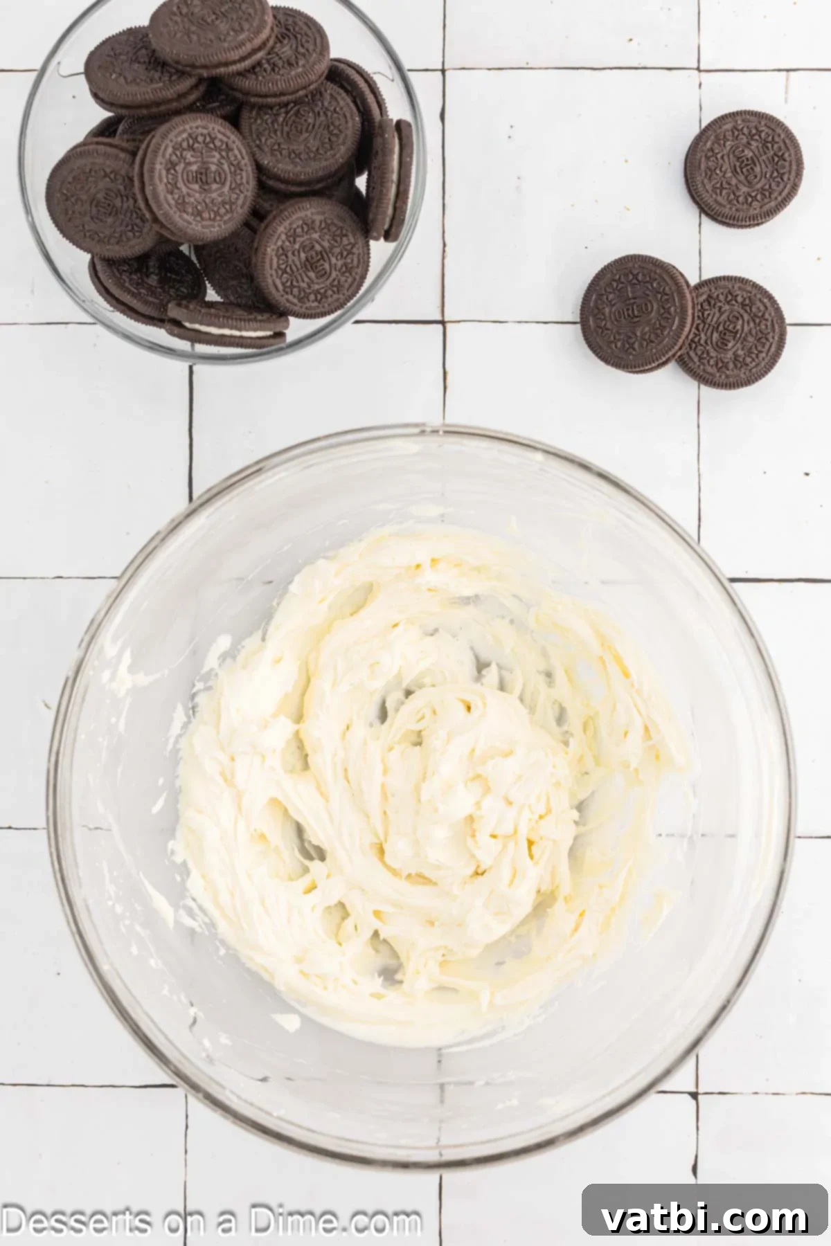 Mixing bowl with cream cheese and sugar combined, ready for vanilla and Oreos.