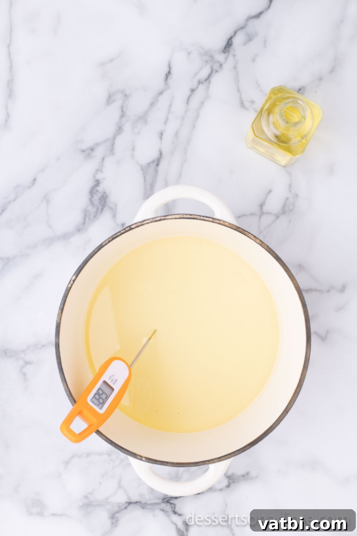 Golden Crisp Cheesecake Indulgence 5 A deep pot filled with vegetable oil, heating on a stovetop, with a thermometer.