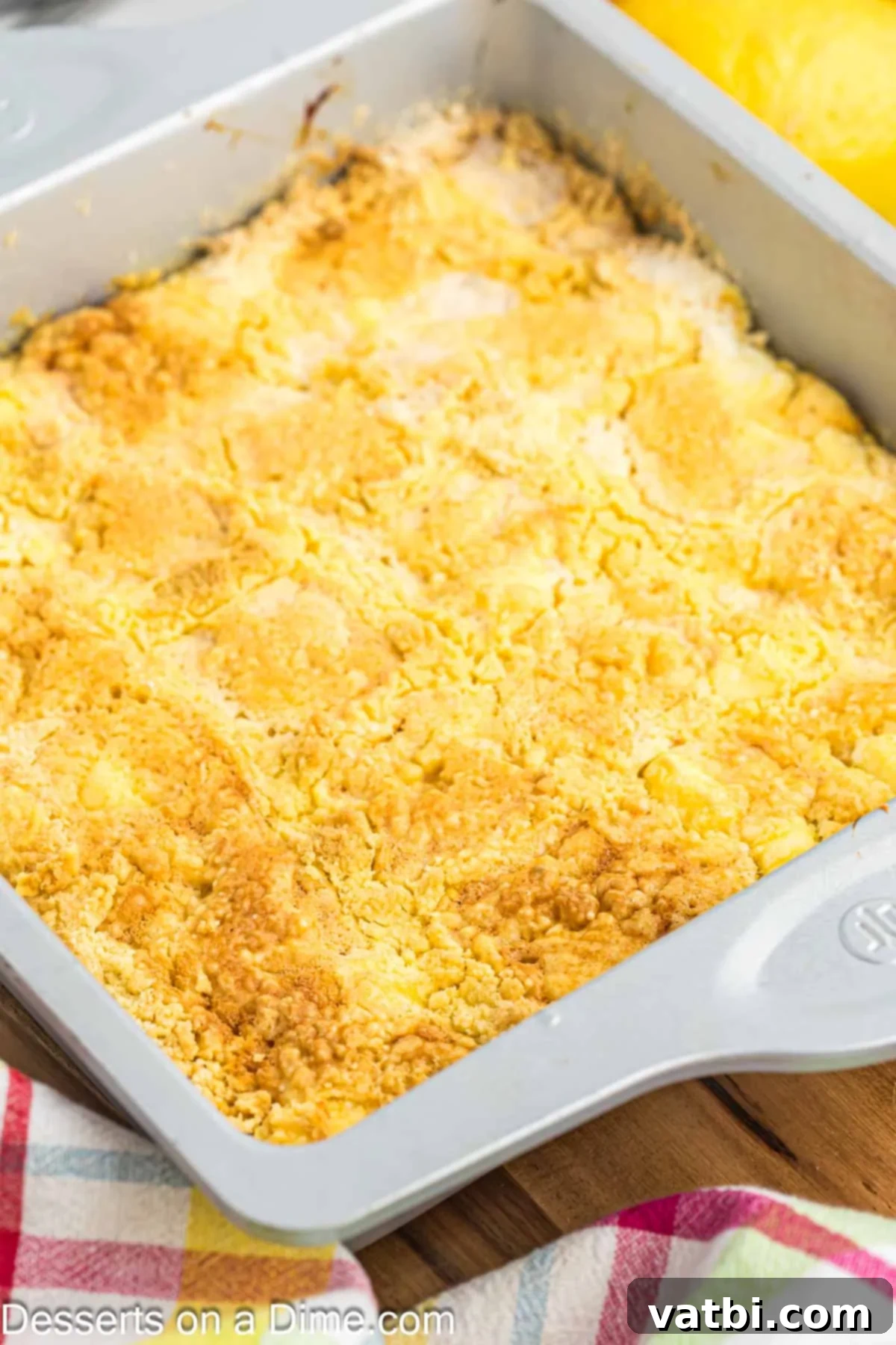 Effortless Lemon Bake 12 A freshly baked Lemon Dump Cake cooling in its white baking pan on a wire rack, steam gently rising.