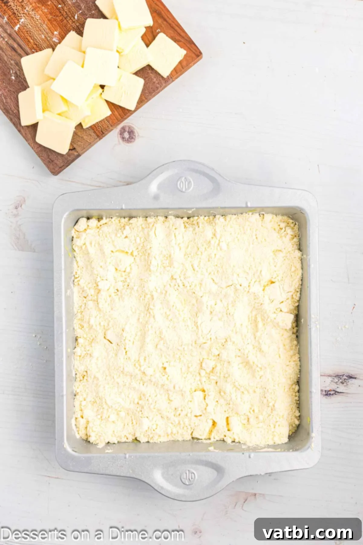 Effortless Lemon Bake 8 The remaining dry cake mix is sprinkled on top of the cream cheese layer, completing the dry ingredient base.