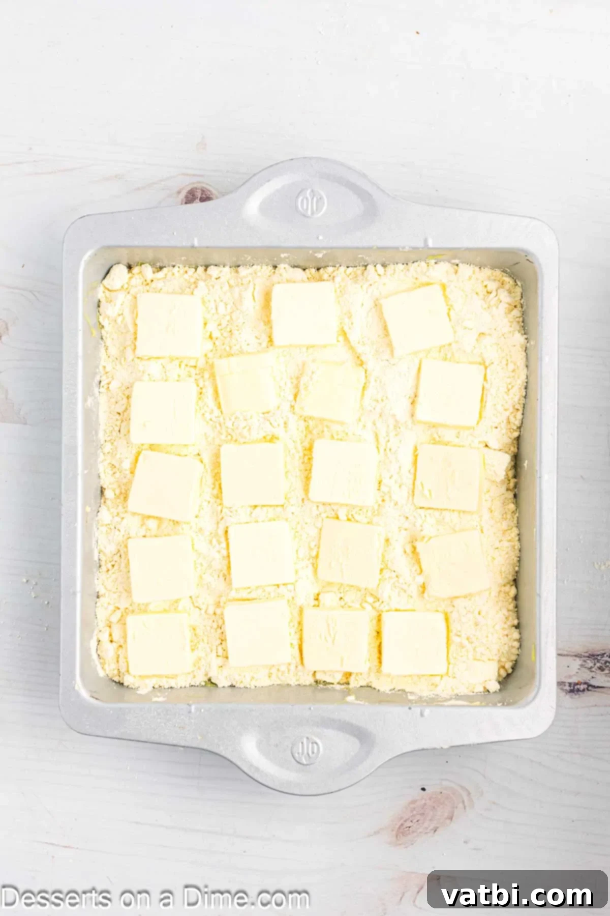 Effortless Lemon Bake 9 Thin slices of butter are arranged in a single layer, covering the entire surface of the dry cake mix for baking.