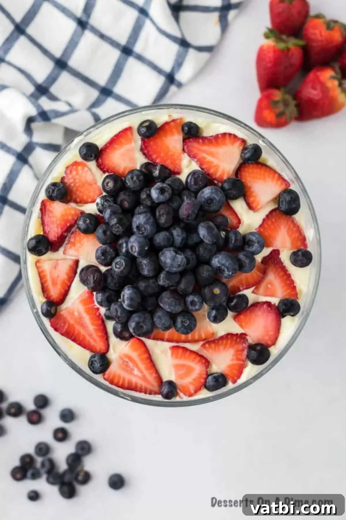 Patriotic Trifle 2 A stunning Red, White, and Blue Trifle in a clear glass container, garnished with whole strawberries and blueberries on top.