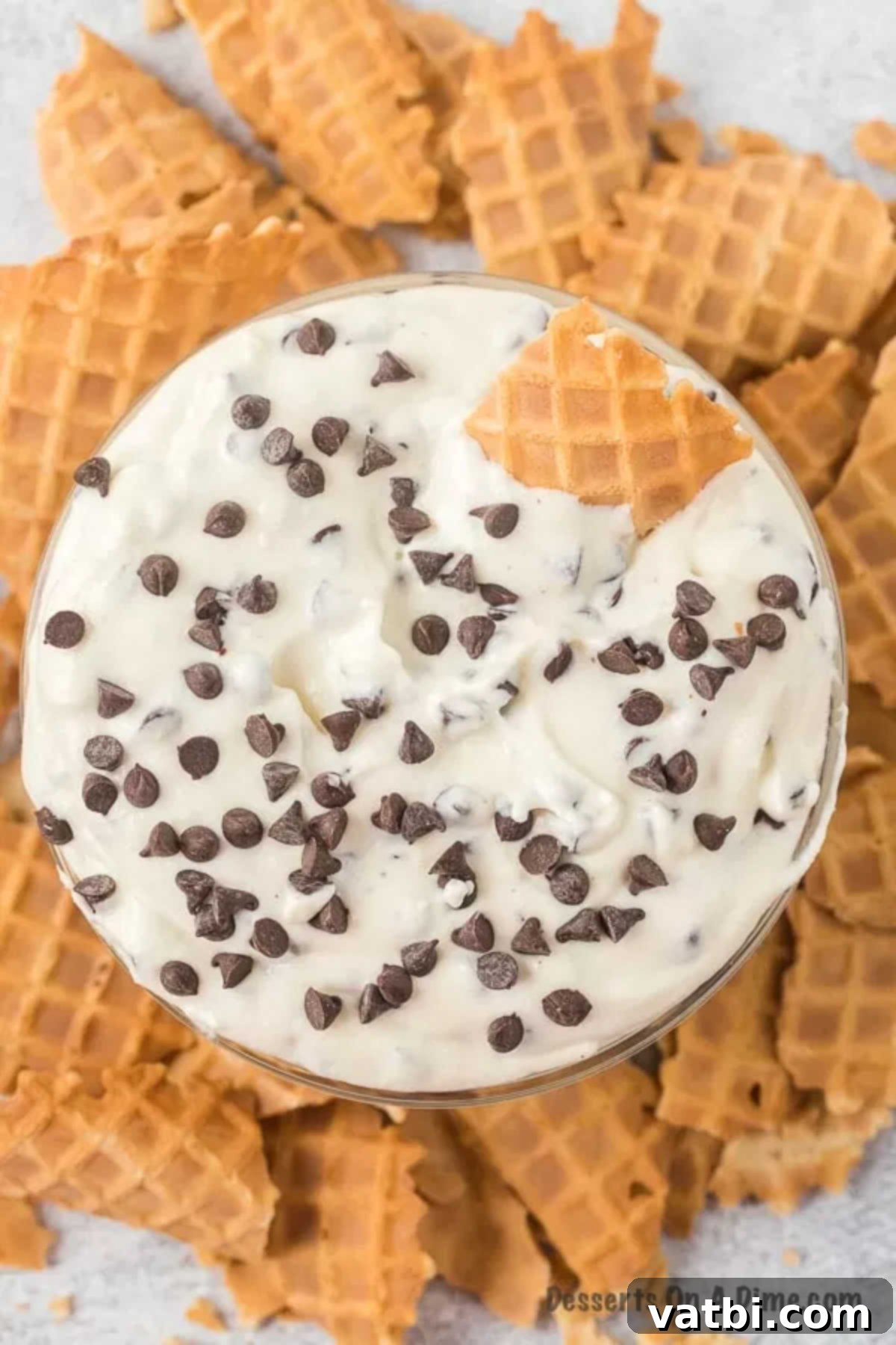 Decadent Cannoli Dip 2 Creamy homemade cannoli dip served in a decorative bowl, surrounded by crispy broken waffle cone pieces for dipping.