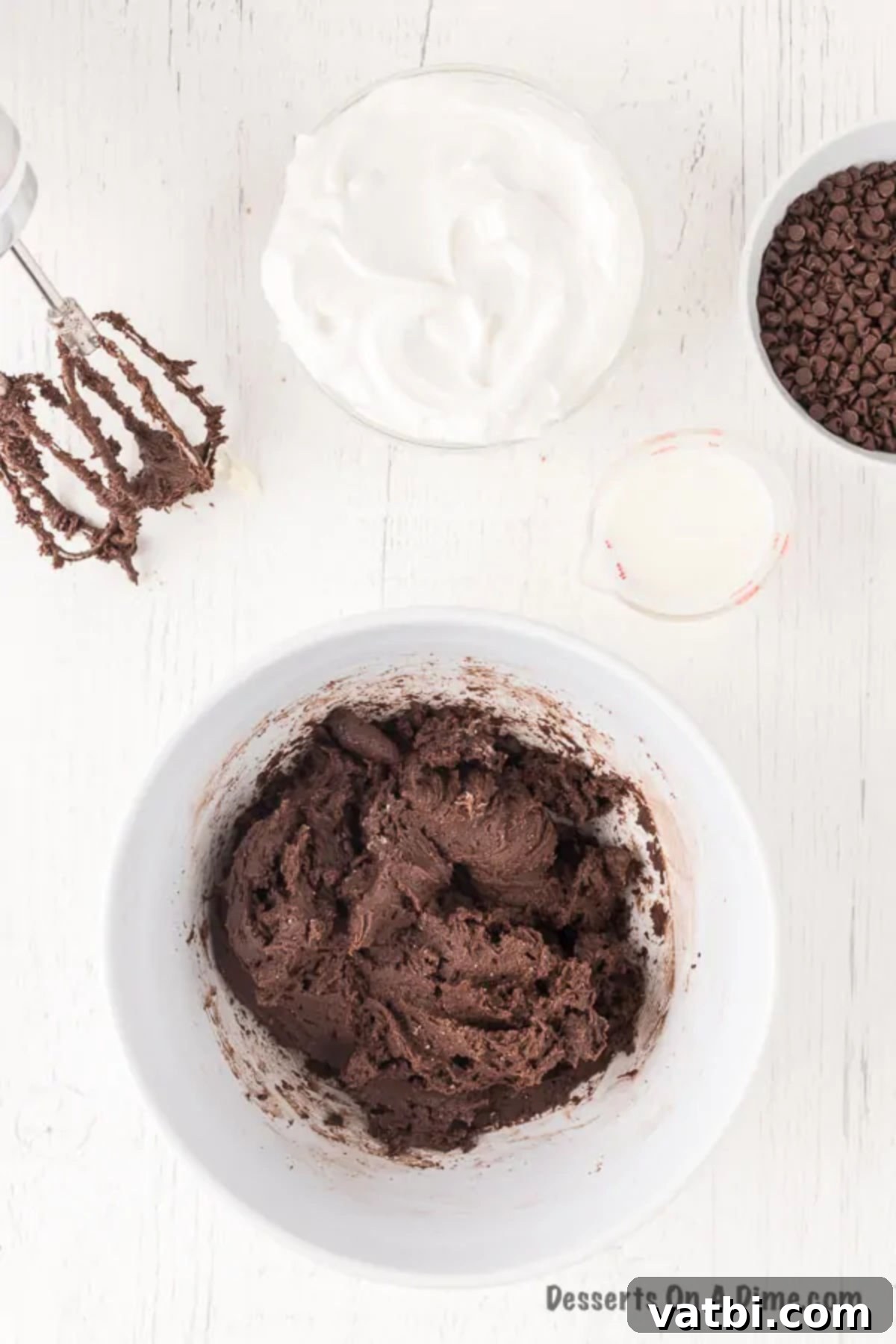Sweet Brownie Indulgence 5 Dry brownie mix being added and stirred into the cream cheese mixture in a bowl.