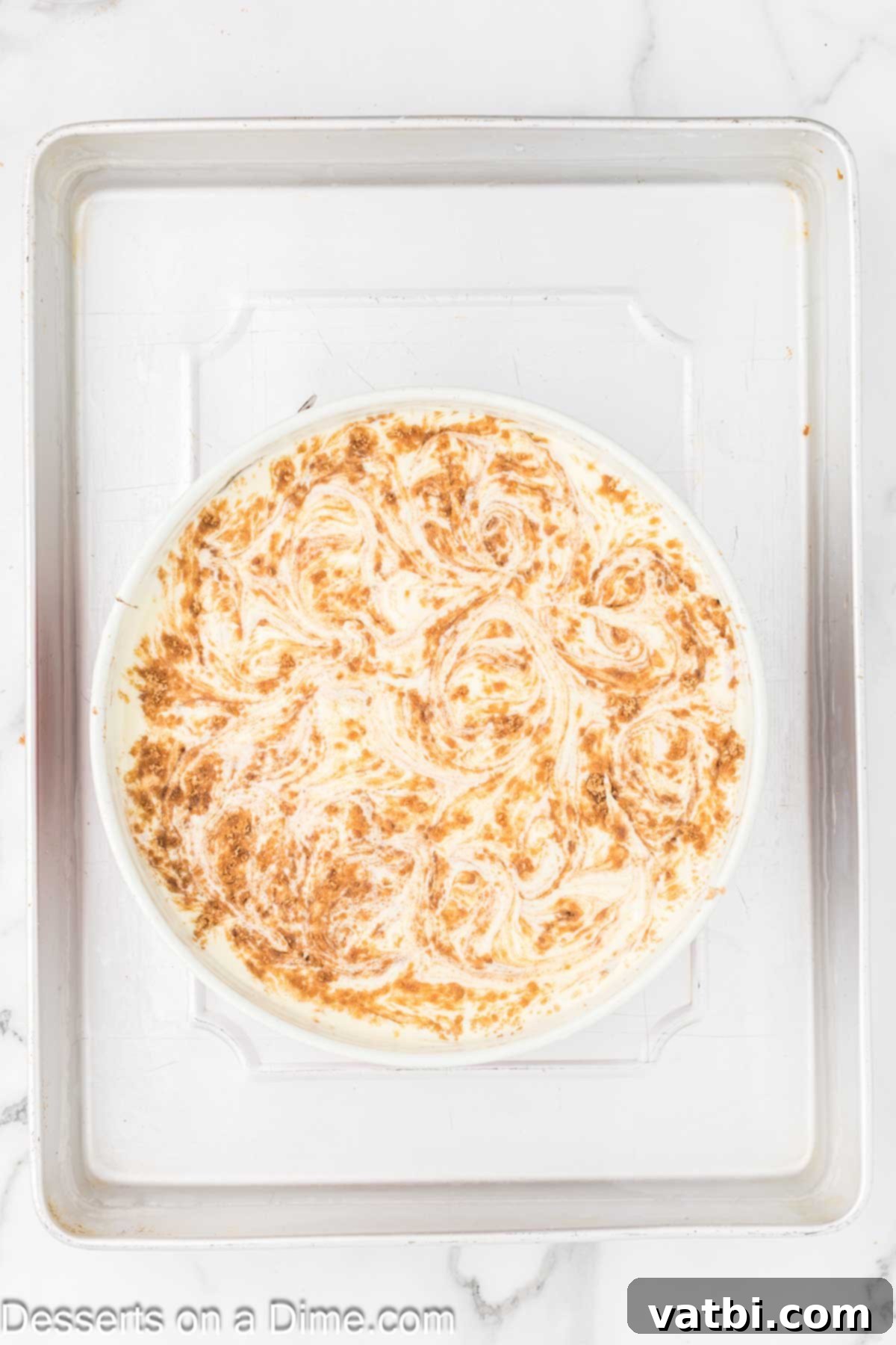 Honey Cinnamon Swirl Cheesecake 10 A knife gently swirling the cinnamon and brown sugar mixture into the cheesecake filling to create a marbled effect.
