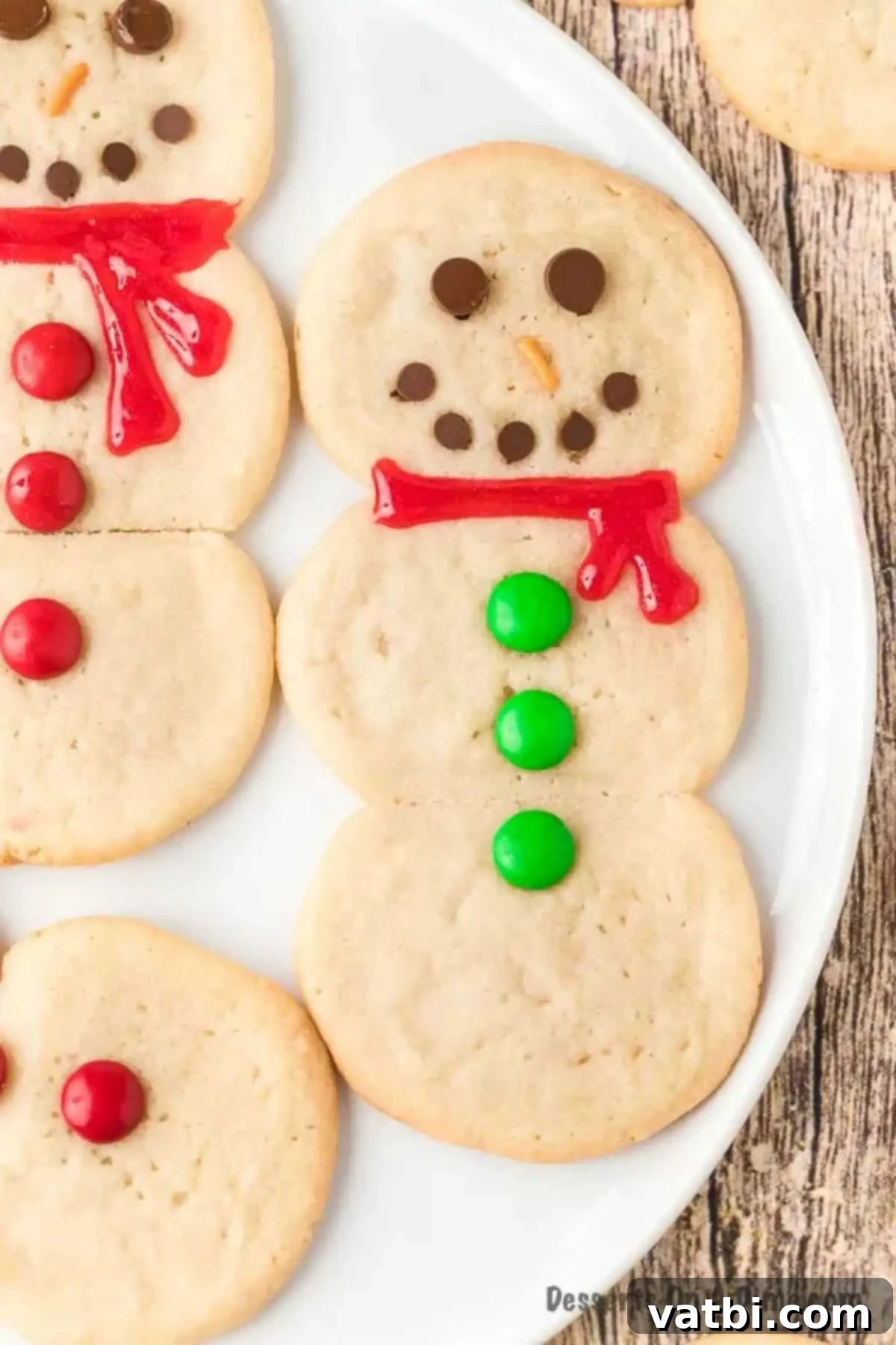 Effortless Snowman Cookie Fun 2 Freshly baked snowman cookies cooling on a baking sheet lined with wax paper, ready for decoration.