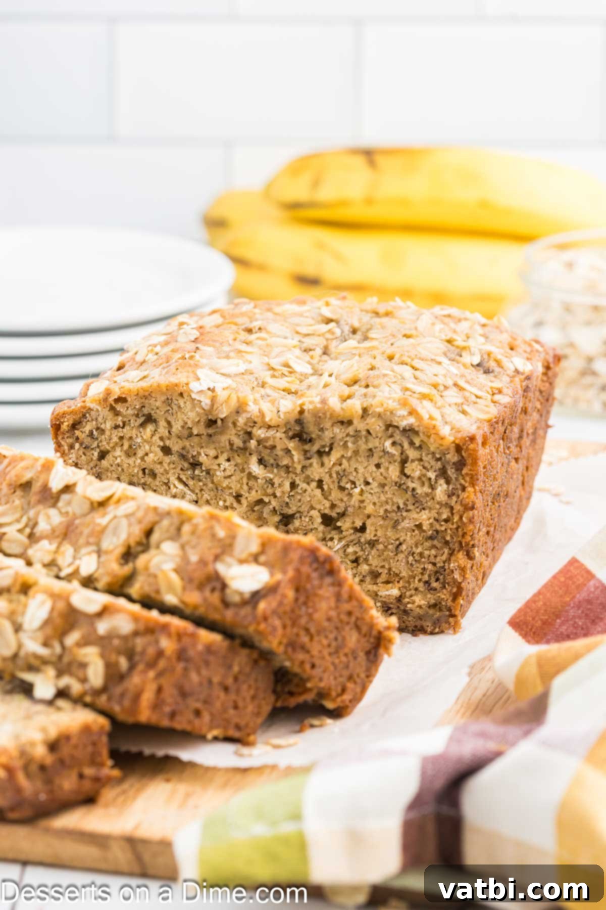 Delicious Banana Oat Bread 2 Freshly baked Oatmeal Banana Bread sliced on a wooden board, ready to serve.