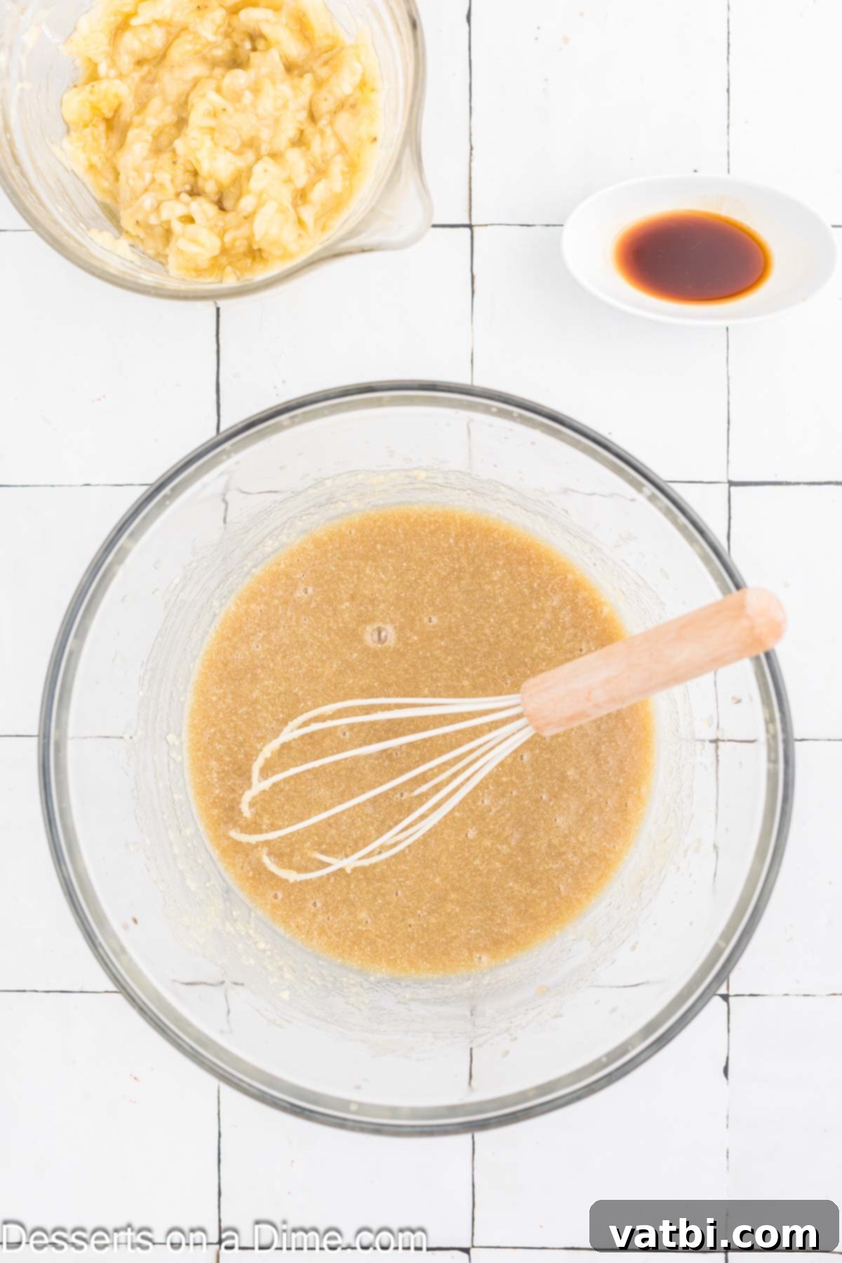 Delicious Banana Oat Bread 4 Brown sugar, milk, and melted butter are combined in a large mixing bowl, being whisked together.