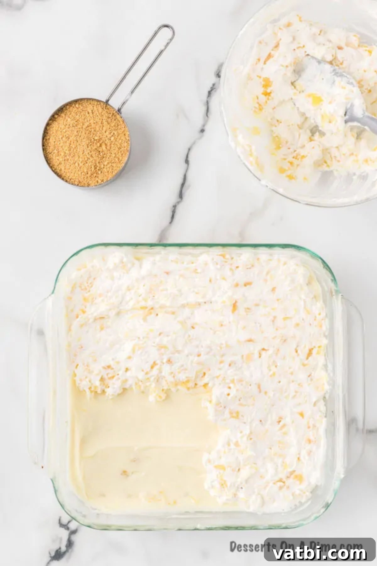 Golden Pineapple Bliss 8 The smooth cream cheese and pineapple mixture evenly spread over the cooled graham cracker crust in the baking dish.
