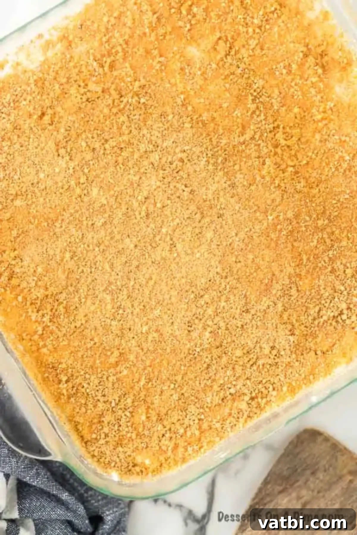 Golden Pineapple Bliss 9 The final layer of whipped topping mixed with pineapple spread over the cream cheese layer, then sprinkled with leftover graham cracker crumbs.