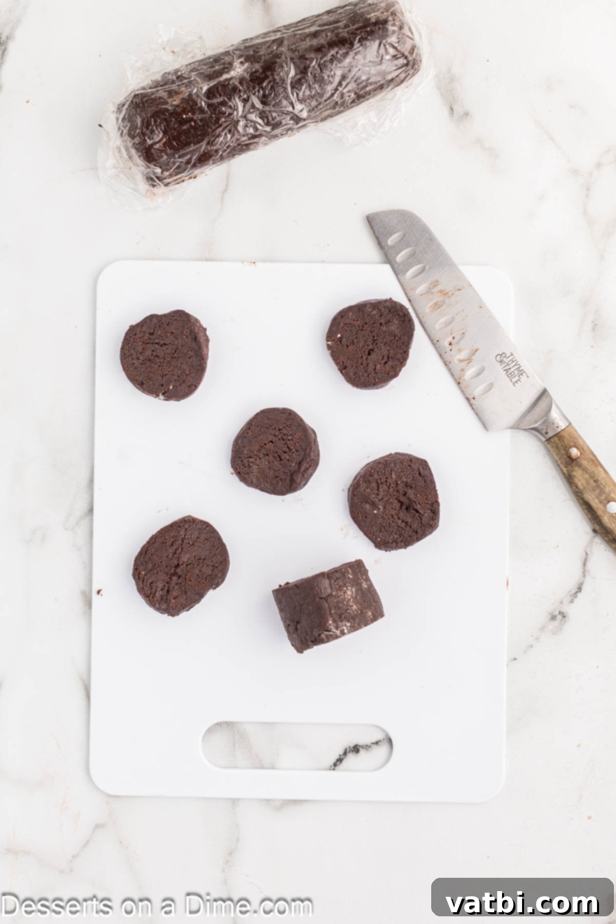 Crispy Chocolate Wafer Delights 9 Chocolate cookie dough logs being sliced into thin rounds for baking.