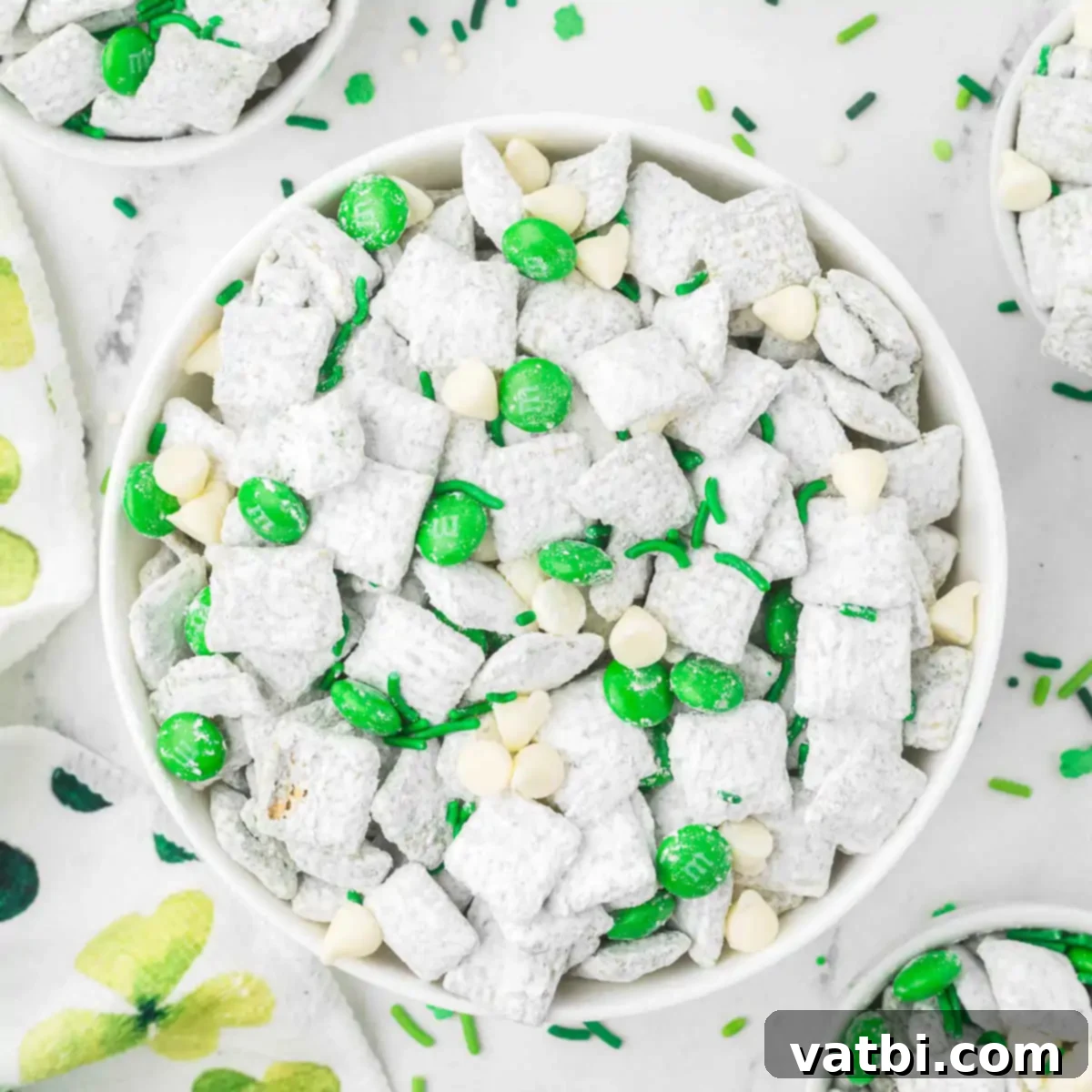 A bowl of freshly prepared St. Patrick's Day puppy chow, garnished with green sprinkles and candies, ready to be enjoyed.