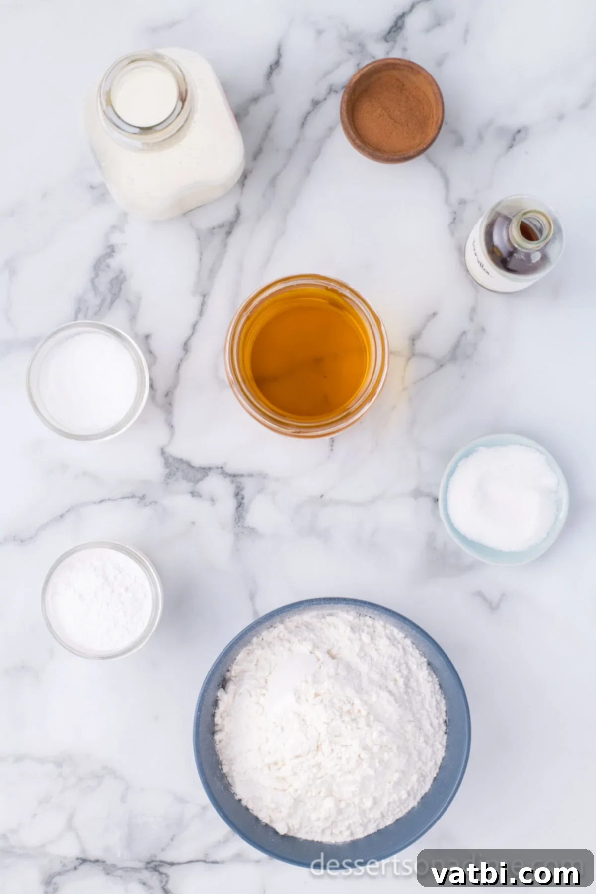 Homemade Elephant Ear Perfection 3 A flat lay of all the essential ingredients laid out on a clean surface to make Elephant Ears: All-Purpose Flour, Salt, Baking Powder, Whole Milk, Frying Oil, Granulated Sugar, and Ground Cinnamon.