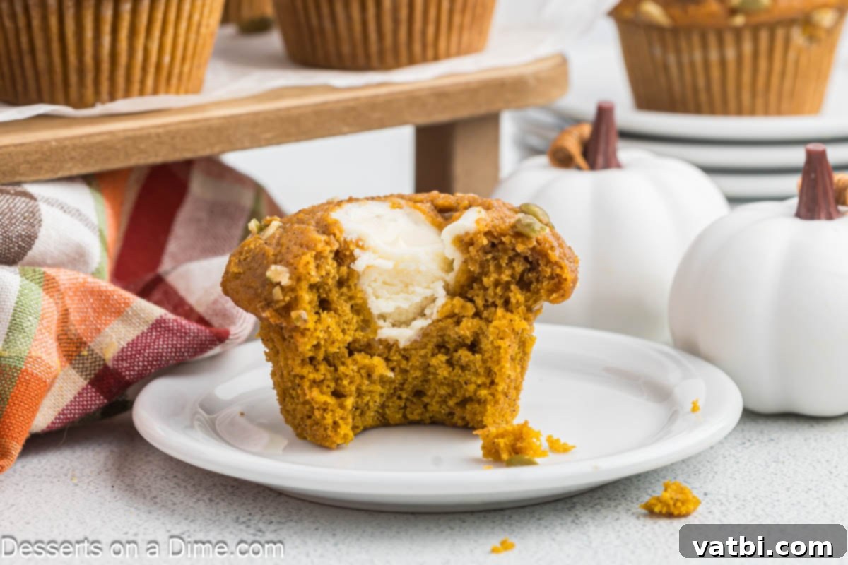 Starbucks Autumn Pumpkin Cream Cheese Muffins 2 Starbucks muffin in half on a white plate, showing the creamy filling.