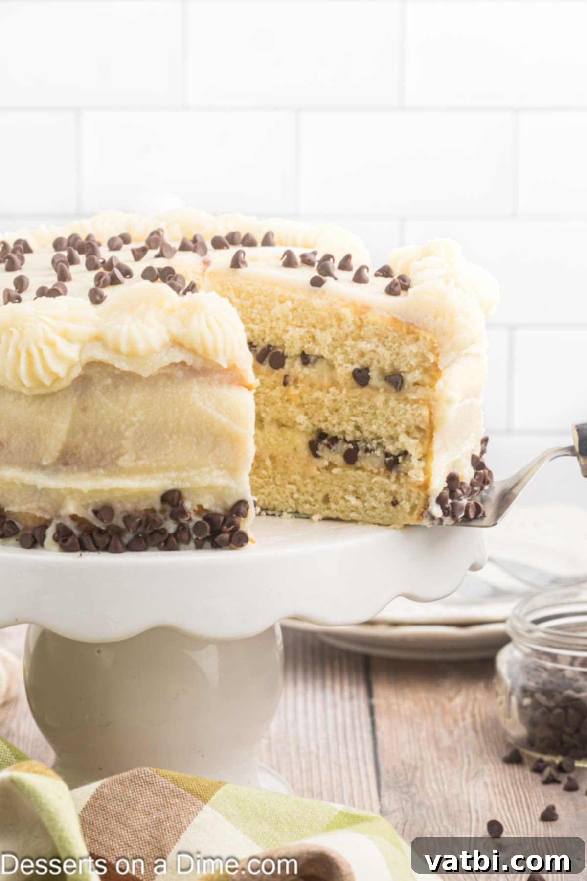 Italian Ricotta Dream Cake 2 A beautiful slice of Cannoli cake showing its layers of moist cake and creamy cannoli frosting with chocolate chips.