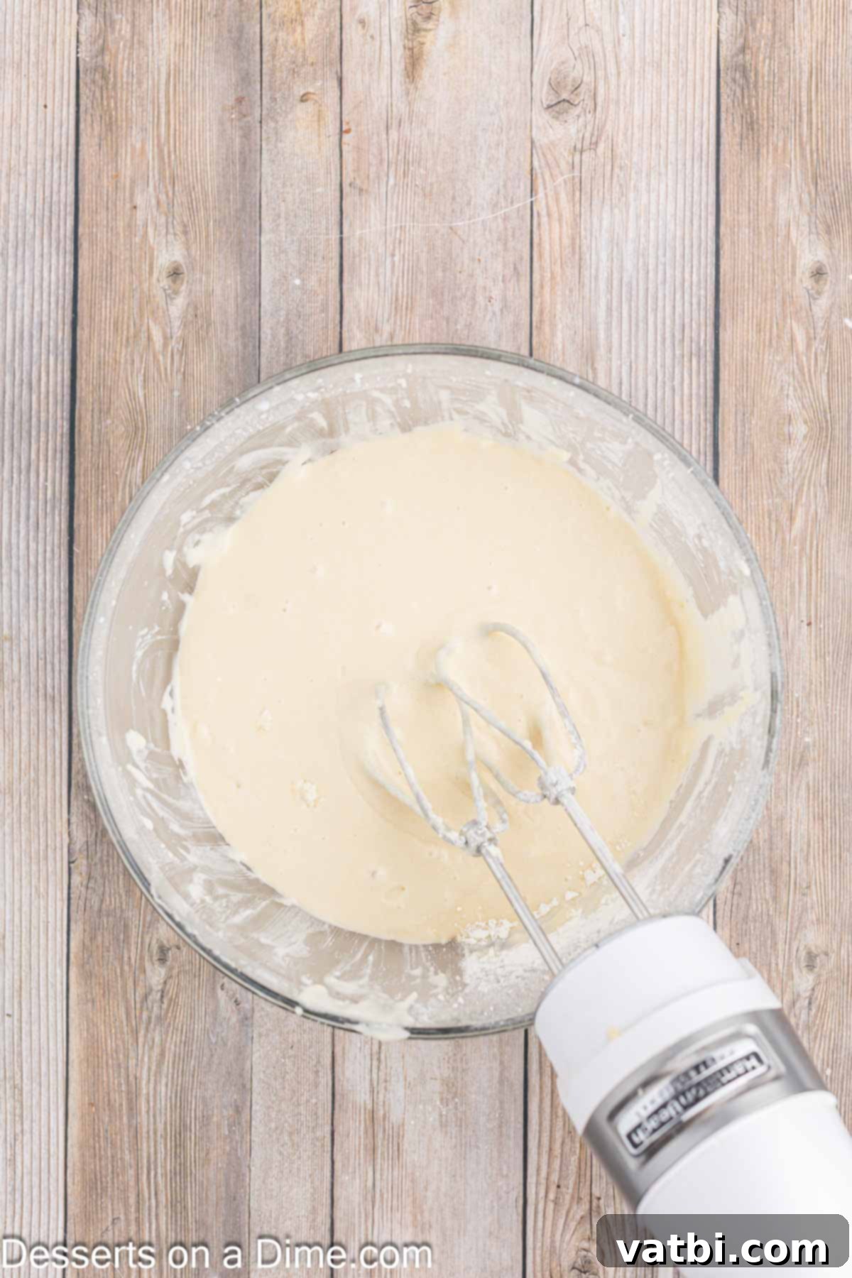 Italian Ricotta Dream Cake 7 Buttermilk and flour being fully incorporated into the cake batter mixture in a mixing bowl.