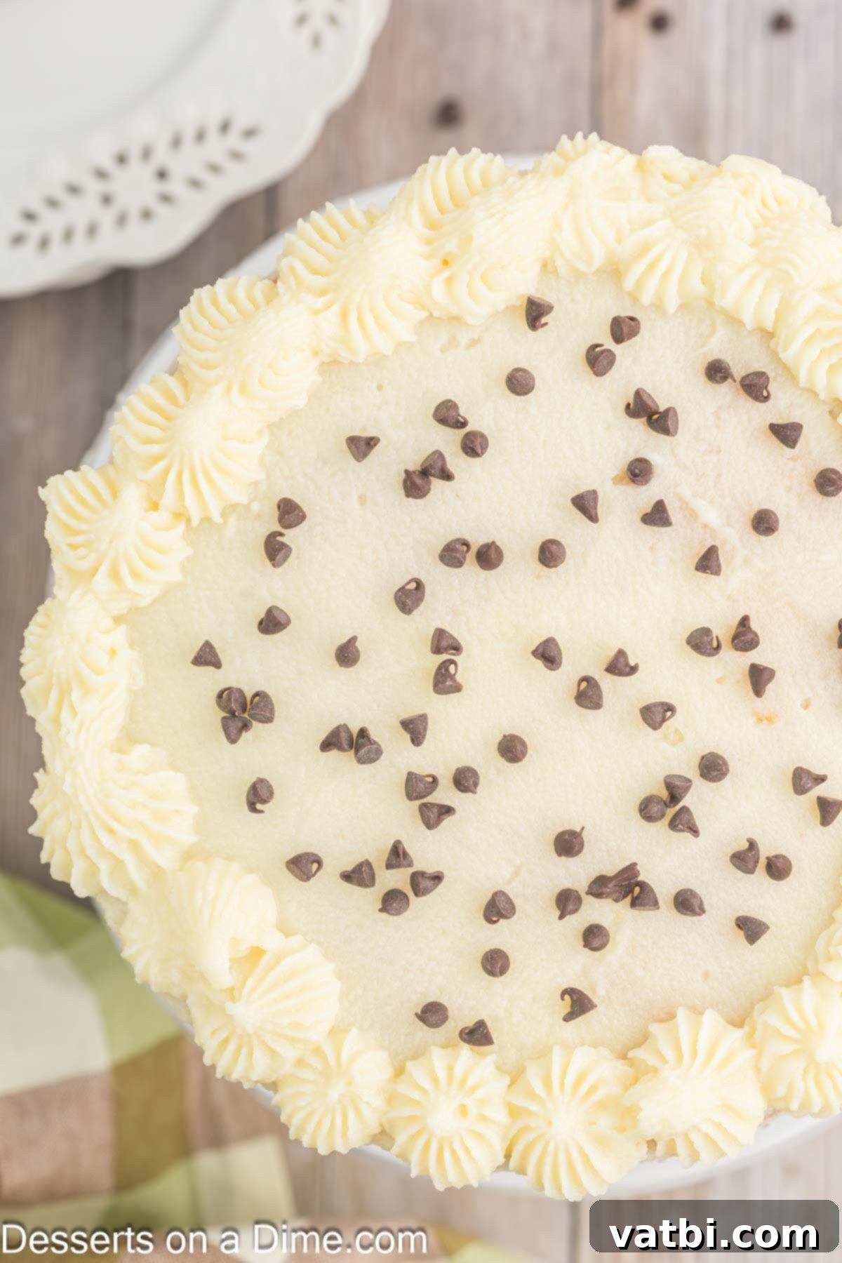 Italian Ricotta Dream Cake 10 The fully assembled Cannoli Cake, elegantly frosted and topped with a sprinkle of mini chocolate chips, ready for final presentation.