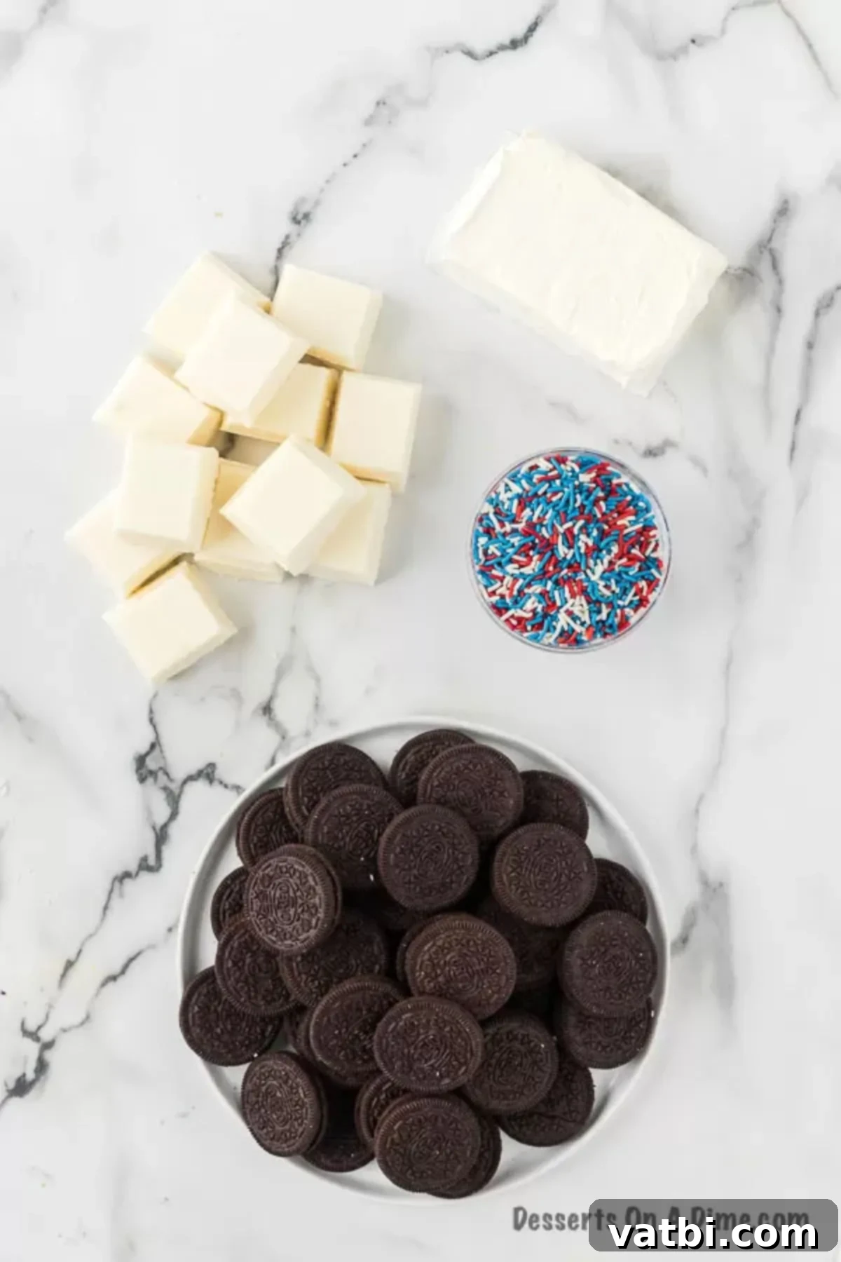 Star-Spangled Oreo Truffles 3 Ingredients laid out for Patriotic Oreo Balls: a block of softened cream cheese, a full package of Oreo cookies, white almond bark, and a container of festive red, white, and blue sprinkles.