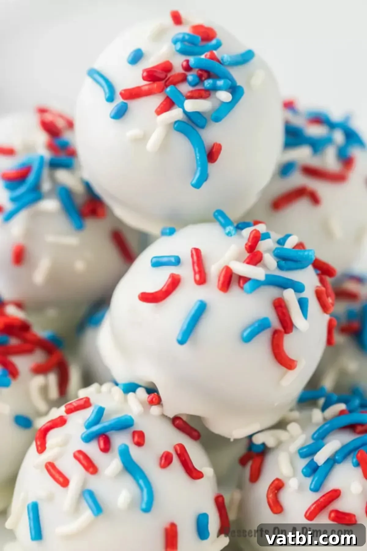 Star-Spangled Oreo Truffles 9 Finished Patriotic Oreo Balls beautifully stacked together on a platter, generously topped with red, white, and blue sprinkles for a festive display.