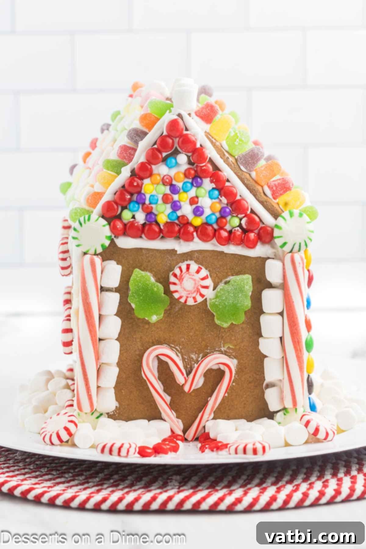 Gingerbread house decorated and on a platter. 