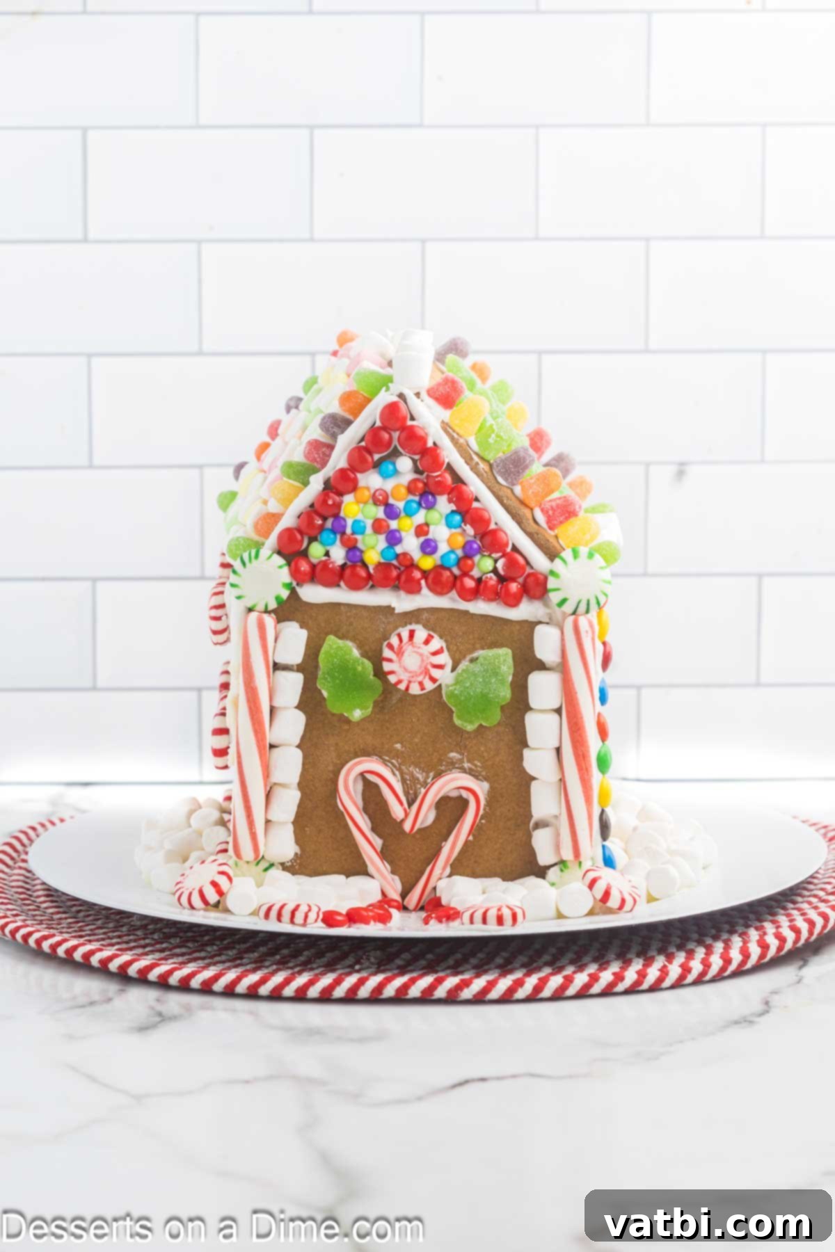 Gingerbread house decorated on a platter. 