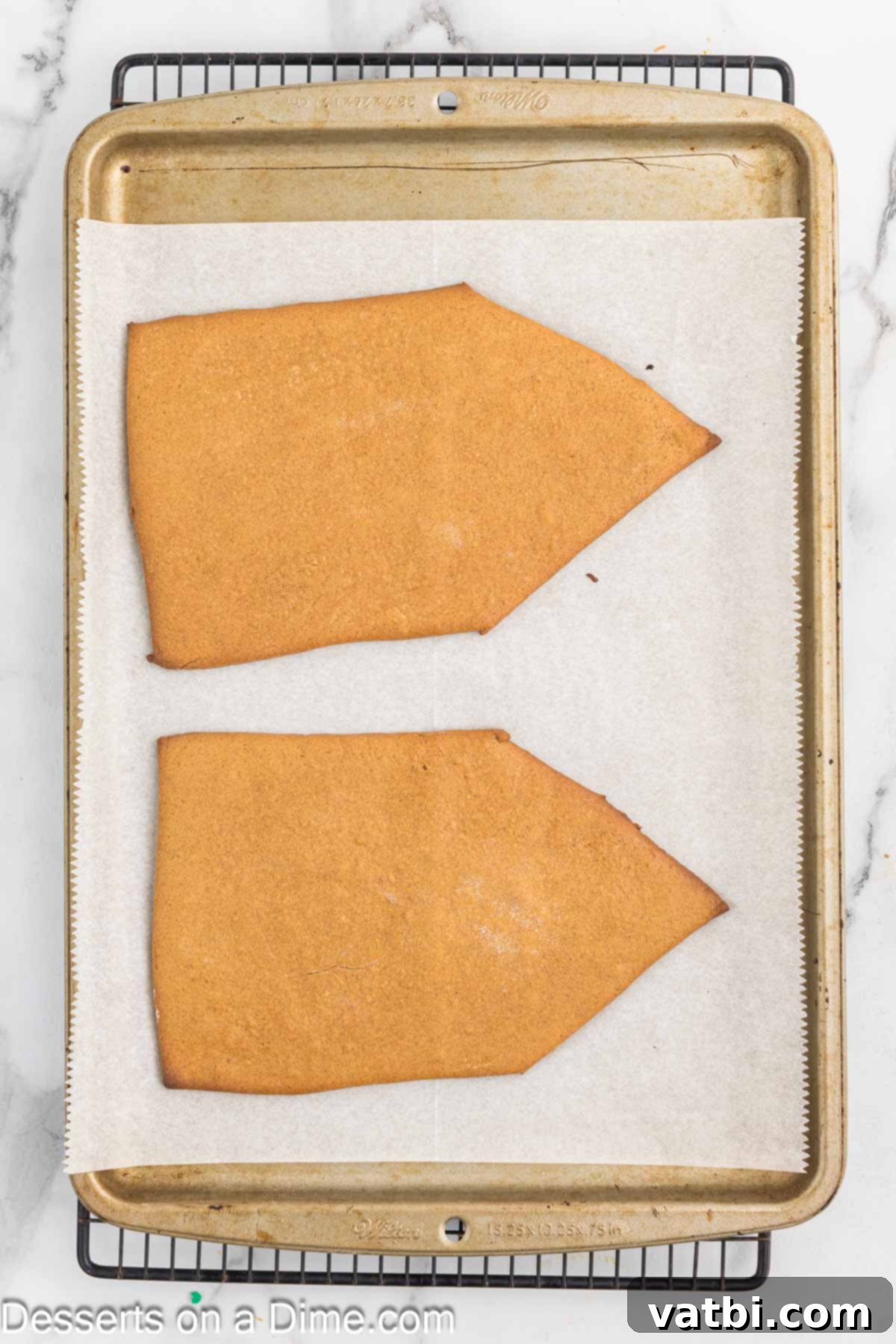 Gingerbread pieces baked and cooling on baking sheet. 