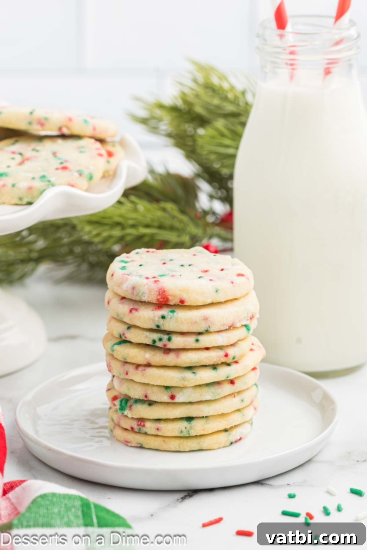 Yuletide Shortbread Delights 2 Christmas Shortbread cookies with sprinkles stacked on a plate, ready to be enjoyed during the holiday season.