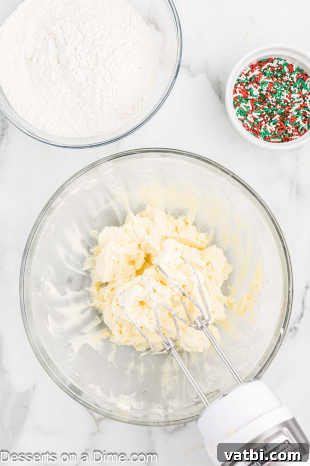 Yuletide Shortbread Delights 4 Softened butter, powdered sugar, and vanilla extract being beaten together until fluffy in a stand mixer bowl.