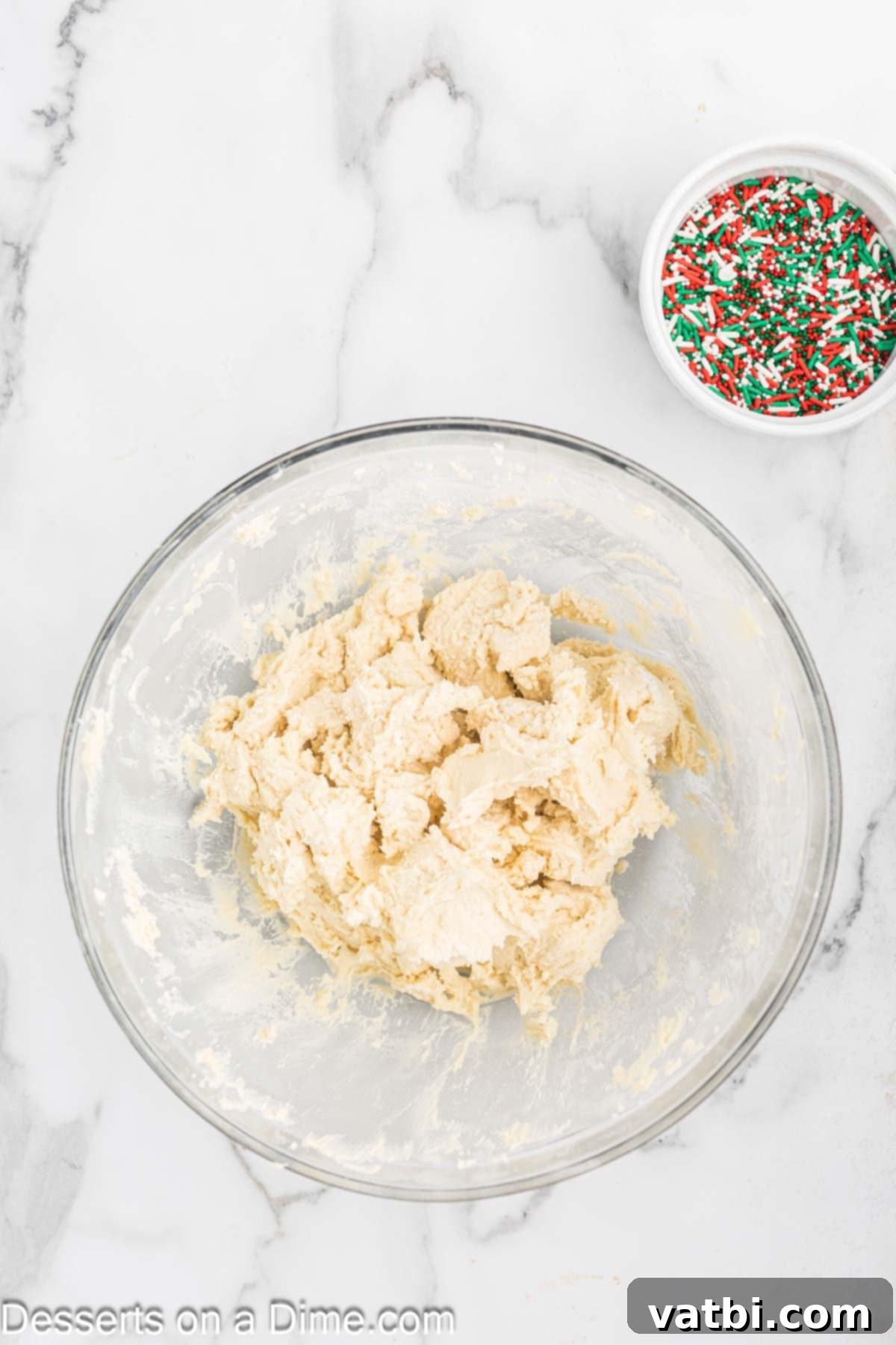 Yuletide Shortbread Delights 5 Sifted dry ingredients (flour and salt) being slowly added to the creamed butter mixture in a mixing bowl.