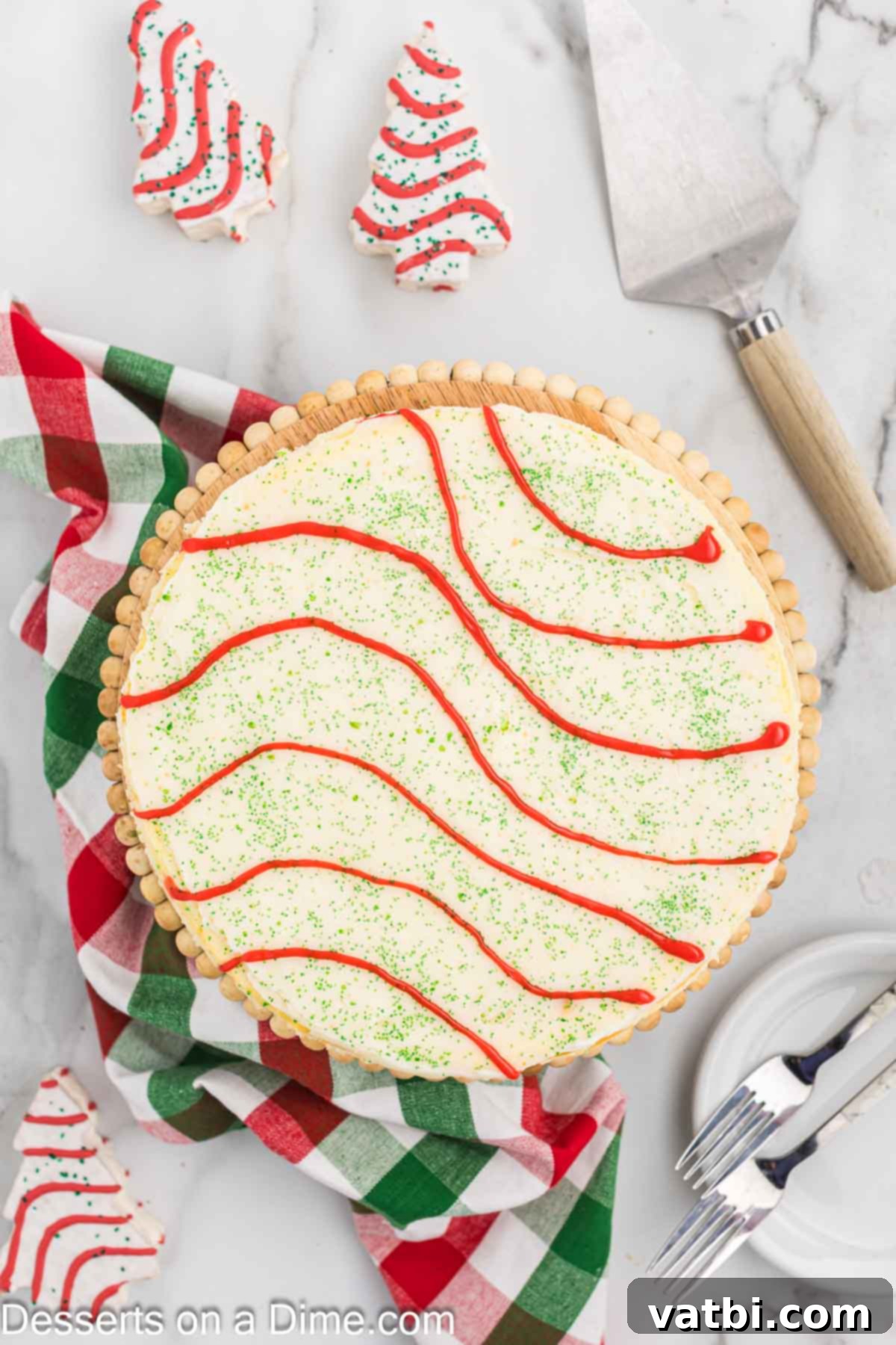Little Debbie Christmas Tree Cheesecake: A Festive Indulgence 16 Red store-bought cookie frosting being piped in decorative stripes over the green sprinkles on the cheesecake.