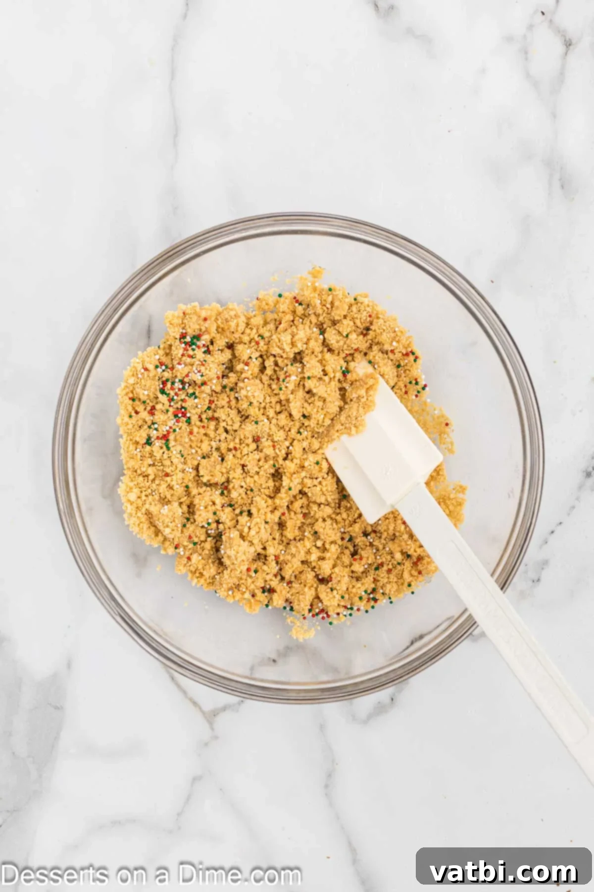Little Debbie Christmas Tree Cheesecake: A Festive Indulgence 4 Oreo crumbs combined with melted butter and sprinkles in a bowl.