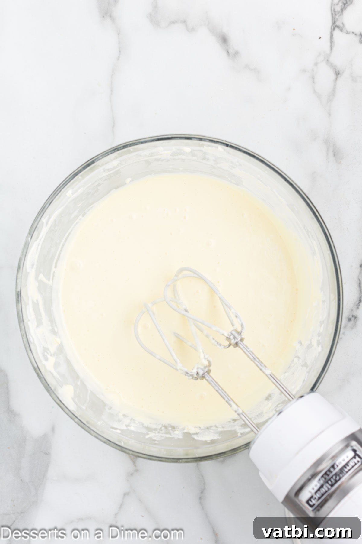Little Debbie Christmas Tree Cheesecake: A Festive Indulgence 9 Sour cream and heavy cream being mixed into the cheesecake batter on low speed.