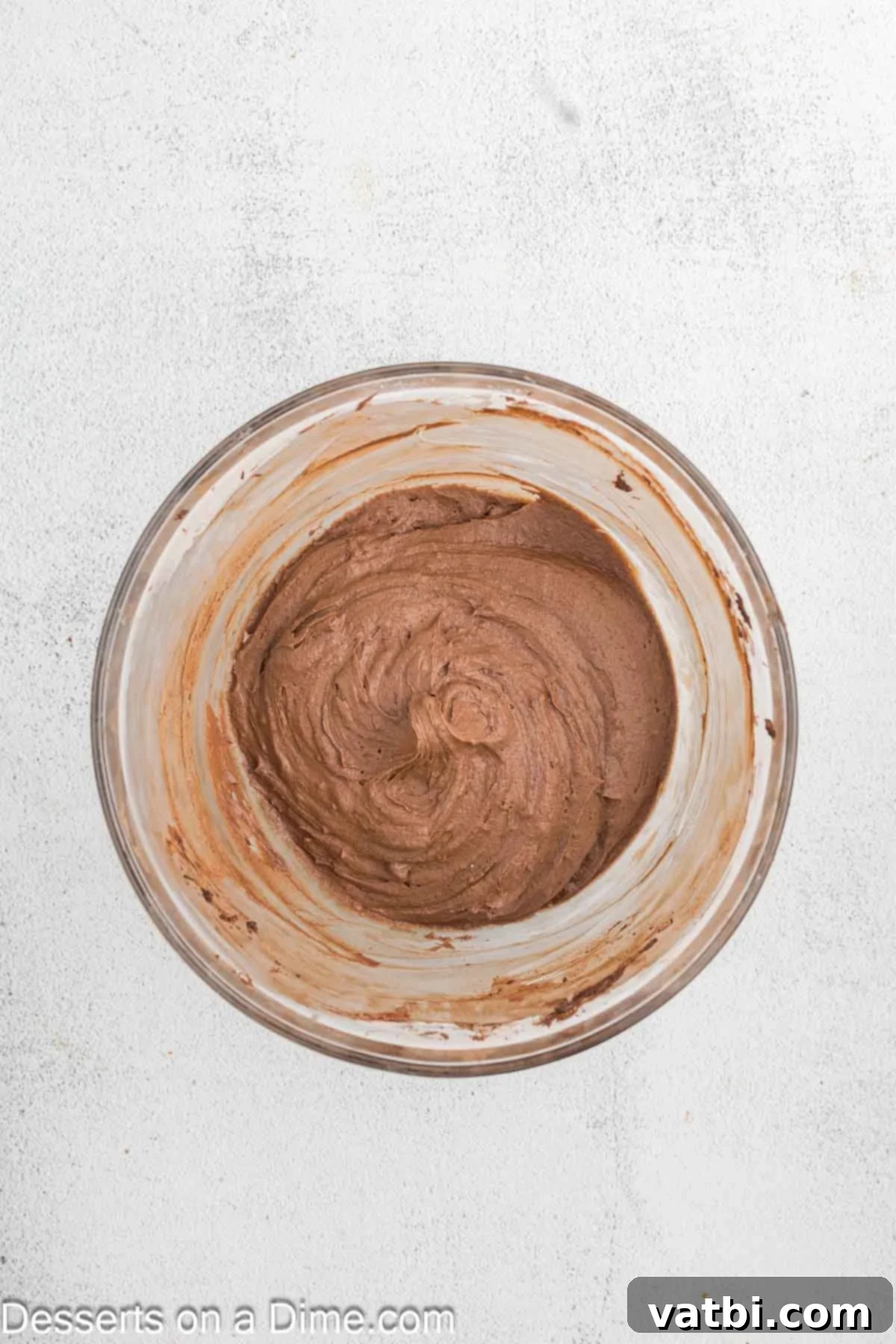 Decadent Chocolate Raspberry Cake 12 Powdered sugar, raspberry filling, vanilla, and milk being mixed into the butter and cocoa powder for the chocolate raspberry frosting.