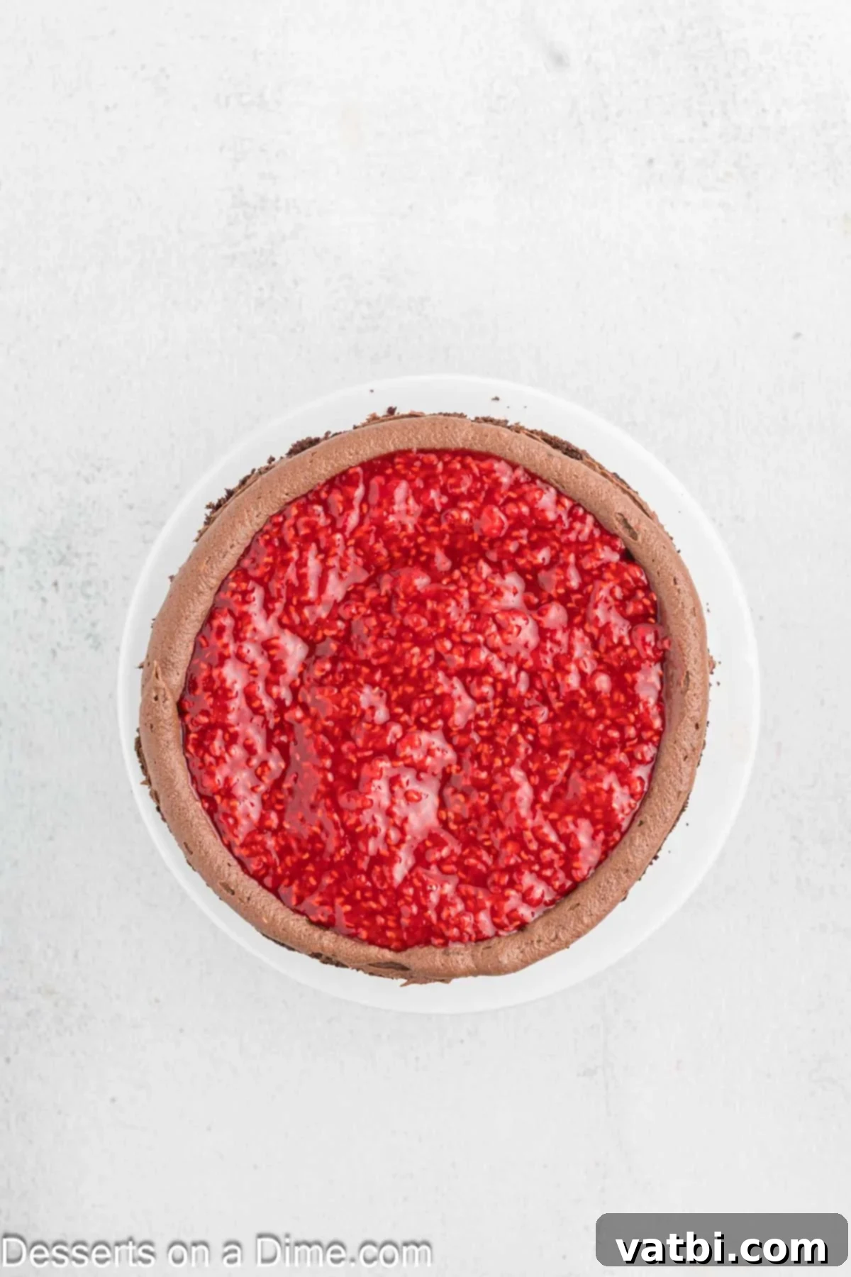 Decadent Chocolate Raspberry Cake 14 Raspberry filling spread inside the piped frosting border on the first cake layer.