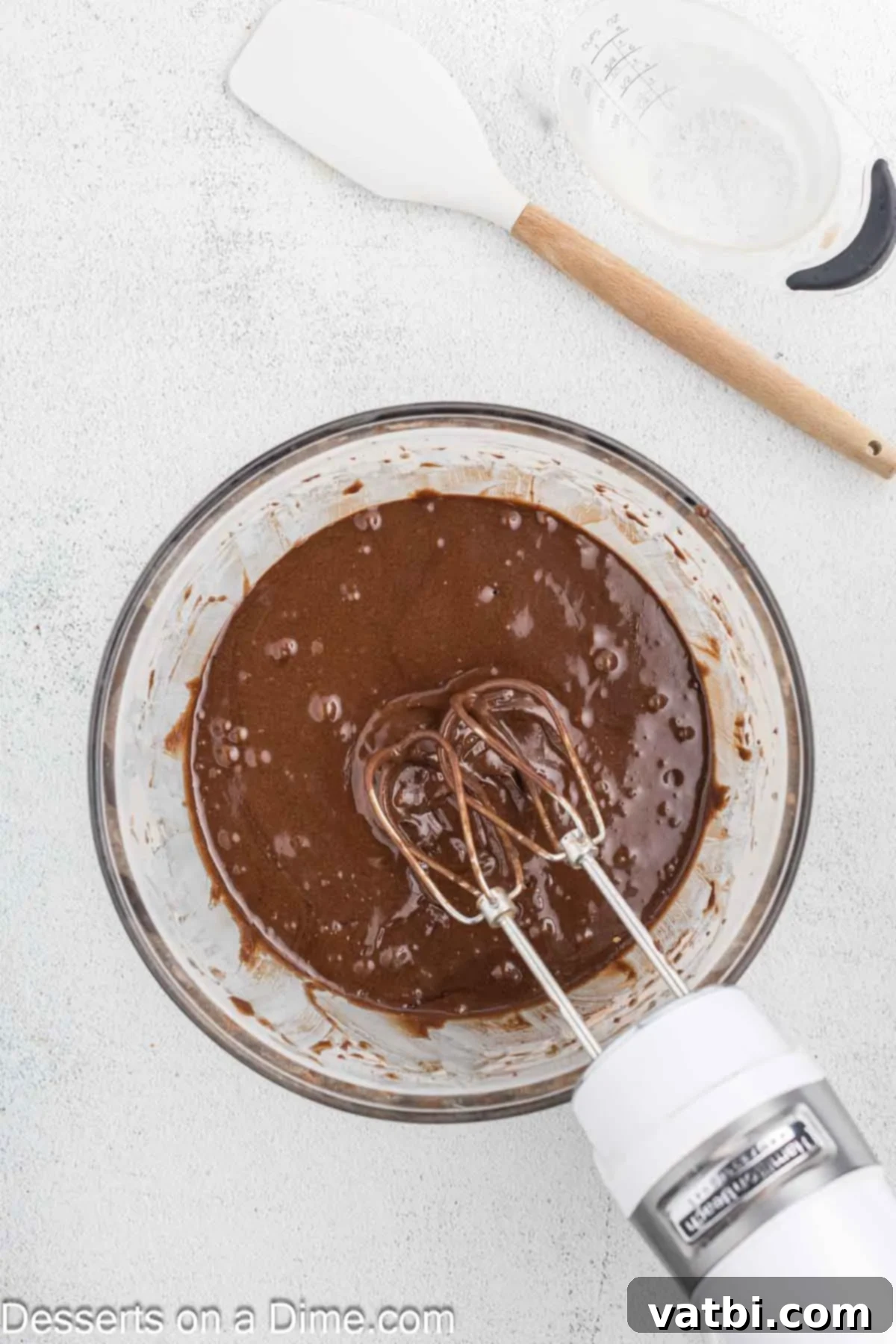 Decadent Chocolate Raspberry Cake 5 Wet ingredients being added and combined with the dry ingredients in a mixing bowl.