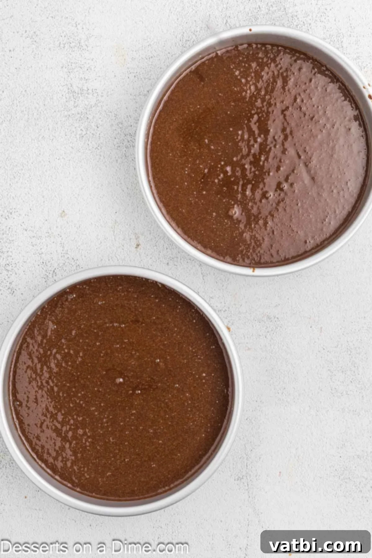 Decadent Chocolate Raspberry Cake 7 Cake batter poured evenly into two prepared round cake pans, ready for baking.
