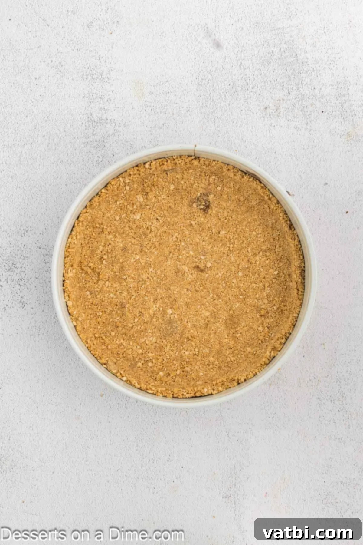 Golden Crown Cheesecake 5 The graham cracker crust mixture firmly pressed into the bottom and slightly up the sides of a 9-inch springform pan.