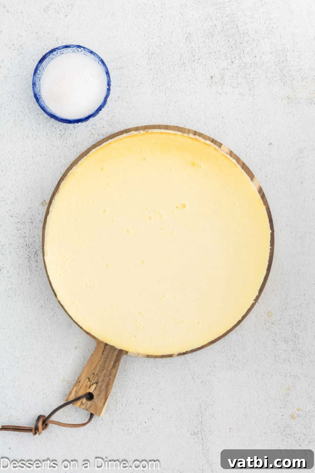 Golden Crown Cheesecake 10 A perfectly baked cheesecake cooling on a wire rack after being removed from the oven and water bath.