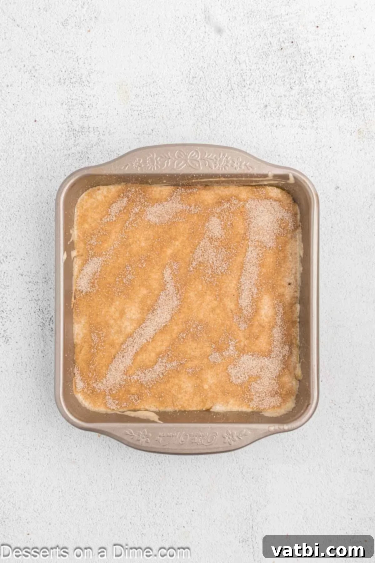 Decadent Churro Cake 12 The final cinnamon sugar mixture generously sprinkled over the top layer of churro cake batter before baking, creating a delicious crust.