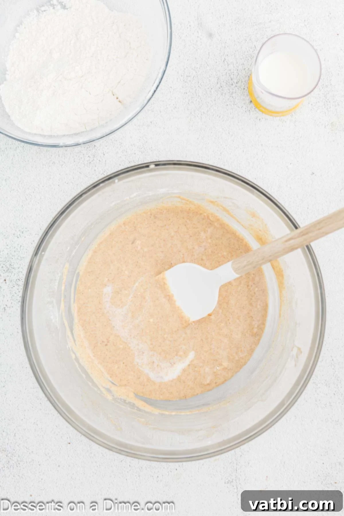 Decadent Churro Cake 7 Sour cream and vanilla extract fully combined into the cake batter, creating a smooth, rich mixture ready for dry ingredients.