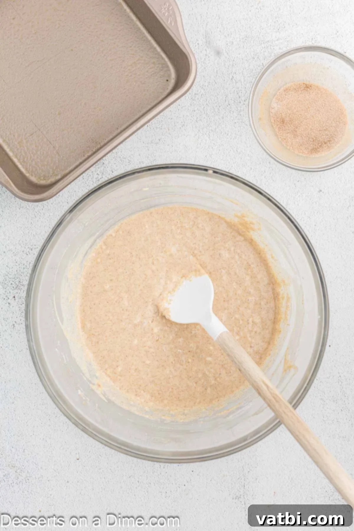Decadent Churro Cake 8 Dry ingredients being gently folded into the wet cake batter by hand, alternating with milk until just combined, creating a smooth consistency.