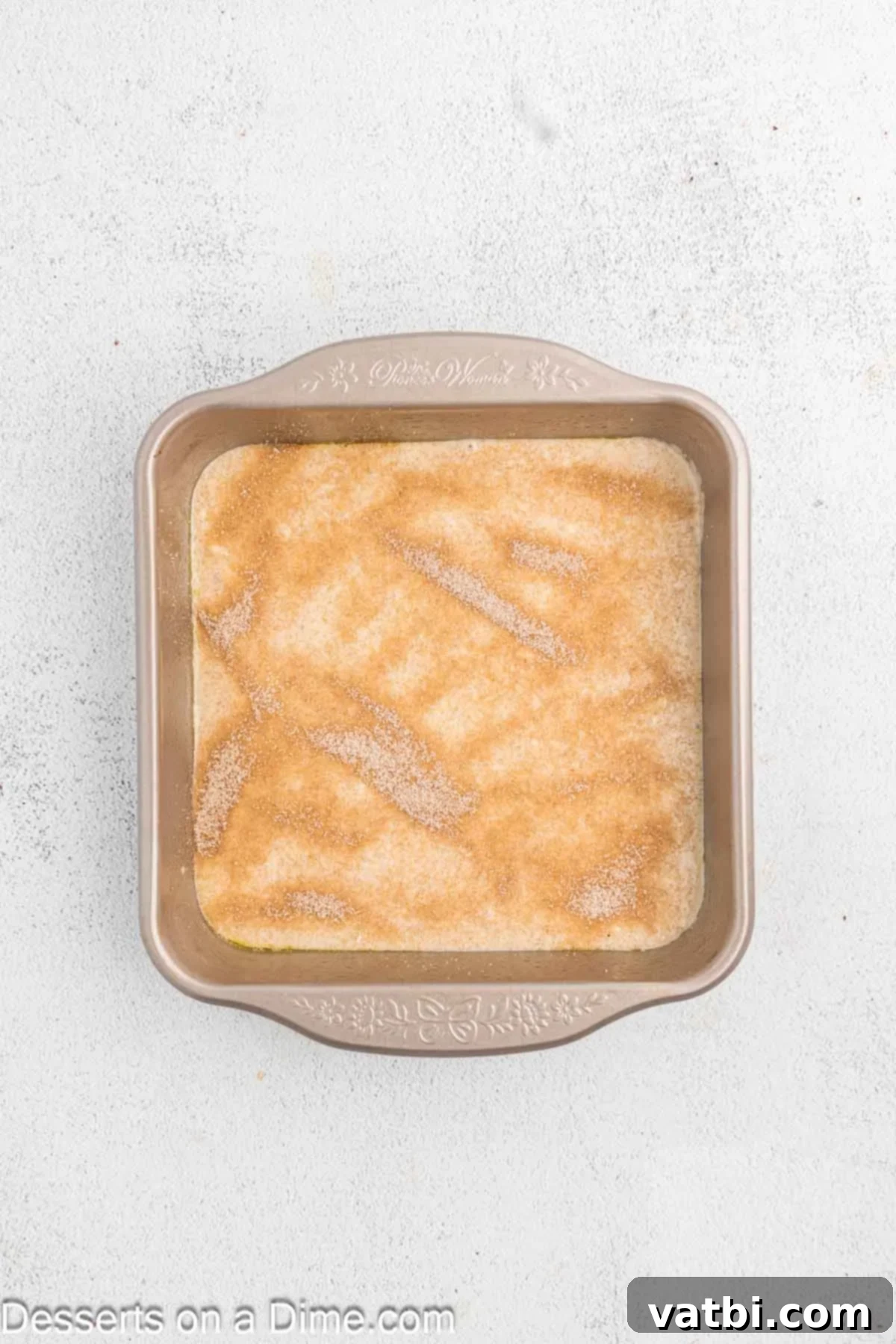 Decadent Churro Cake 10 A generous layer of cinnamon sugar mixture sprinkled evenly over the first half of the cake batter in the baking pan, creating a delicious inner swirl.