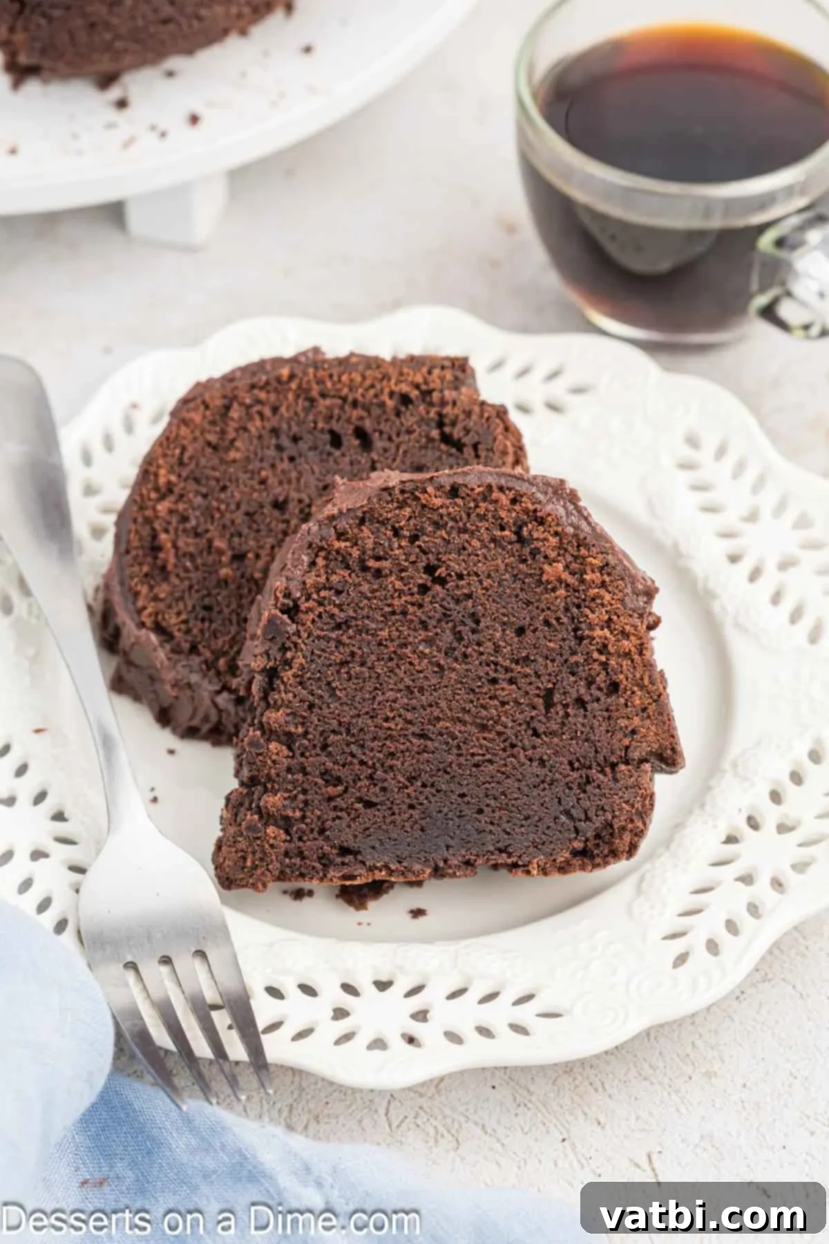 Decadent Chocolate Pound Cake 11 A beautiful slice of chocolate pound cake, garnished with chocolate frosting, displayed on a white plate, ready to be enjoyed.