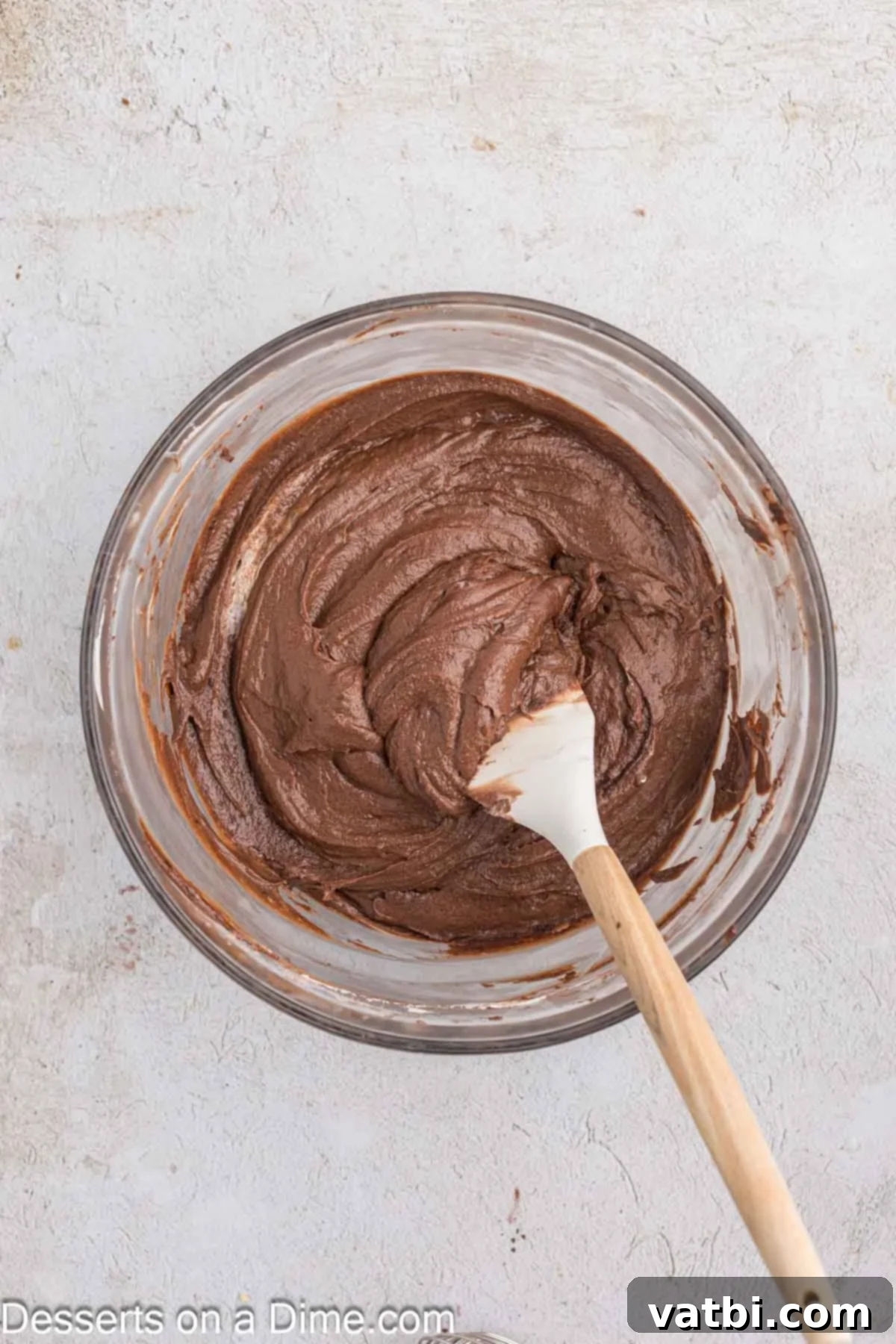 Decadent Chocolate Pound Cake 6 The previously combined dry ingredients (flour, cocoa) are gently mixed into the wet butter and egg mixture in a large bowl, forming a thick chocolate batter.